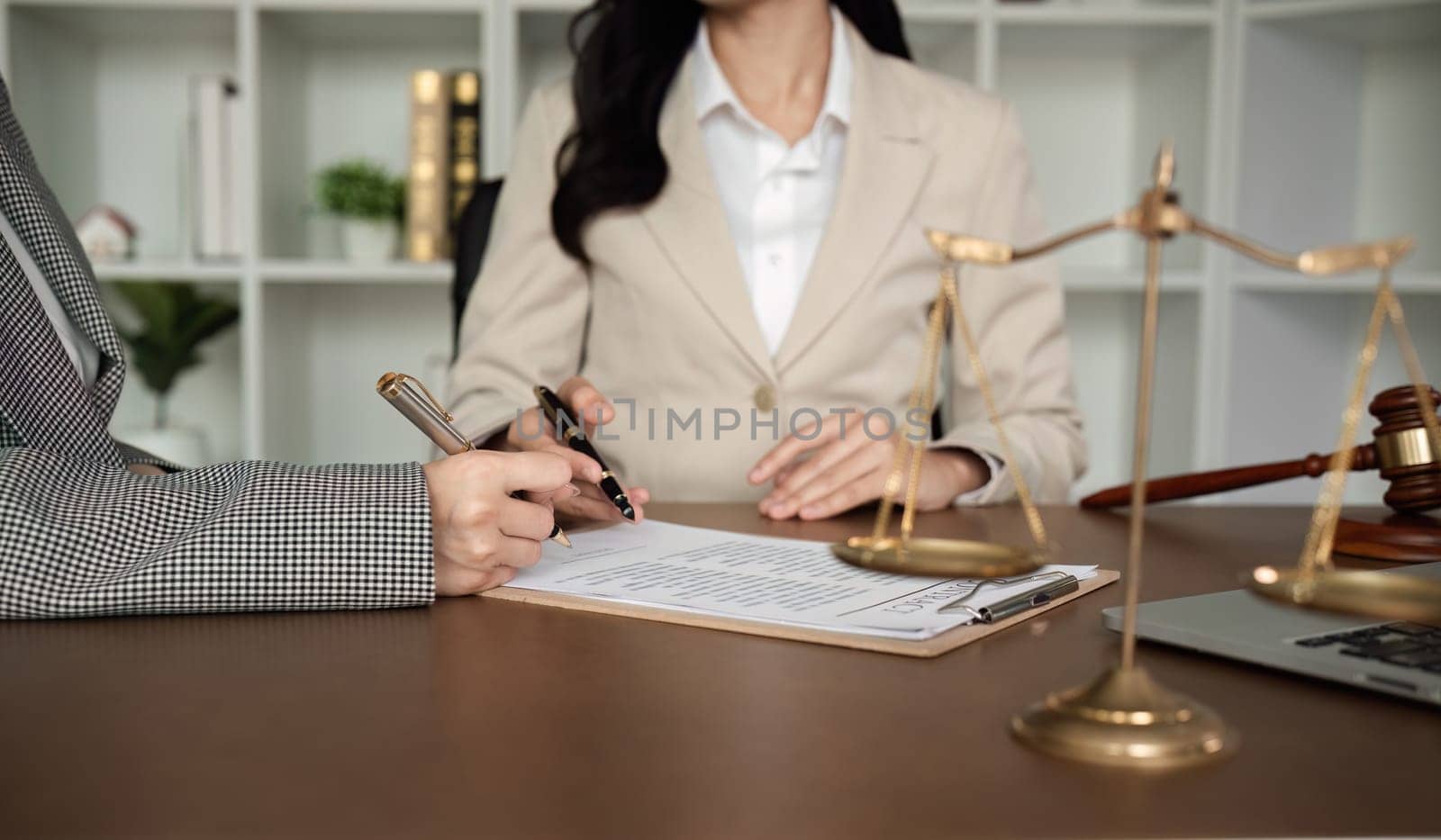 Lawyer and businesswomen discussing and introducing Providing legal advice regarding signing insurance contracts or financial contracts.