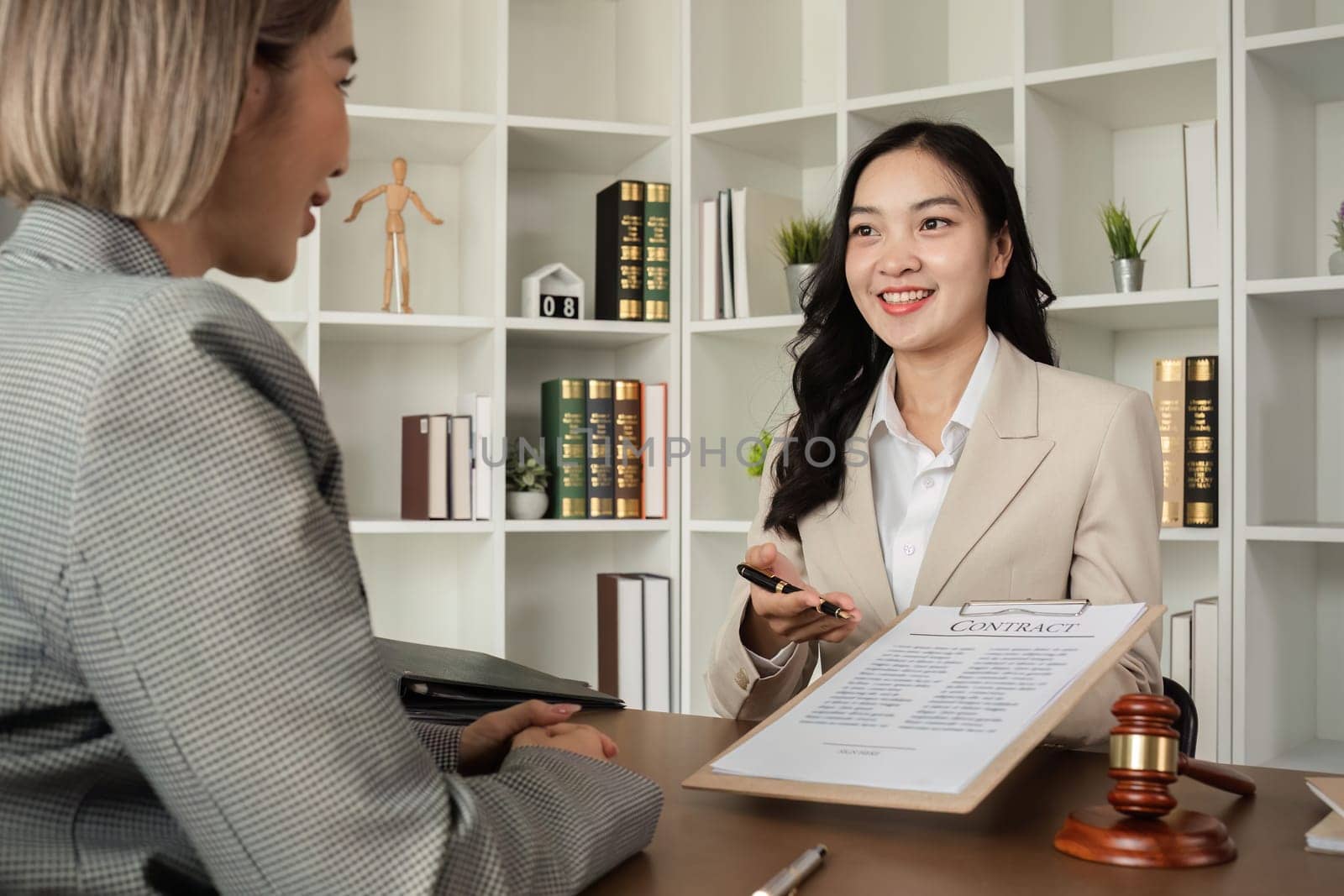 Lawyer and businesswomen discussing and introducing Providing legal advice regarding signing insurance contracts or financial contracts by wichayada