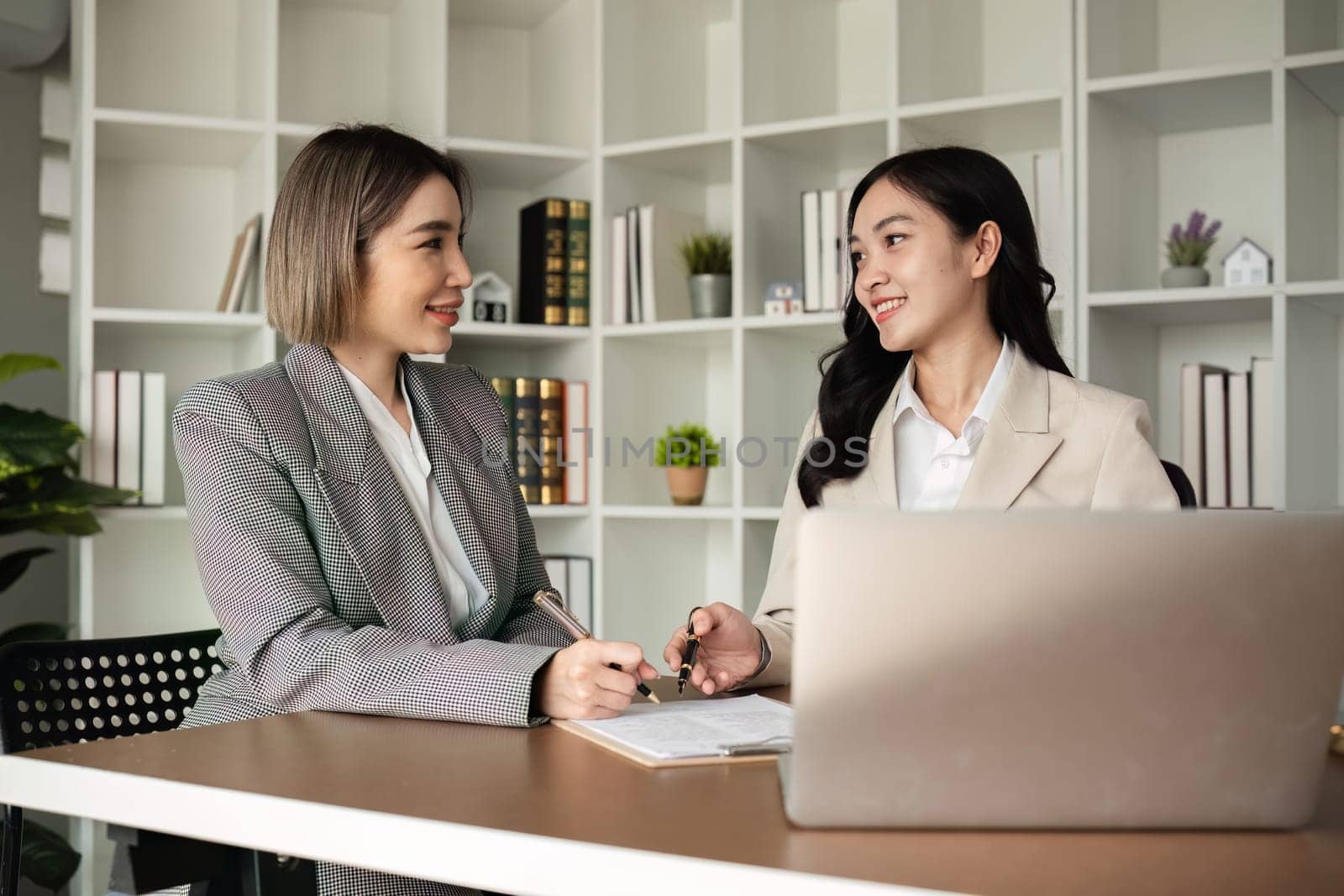 Lawyer and businesswomen discussing and introducing Providing legal advice regarding signing insurance contracts or financial contracts by wichayada