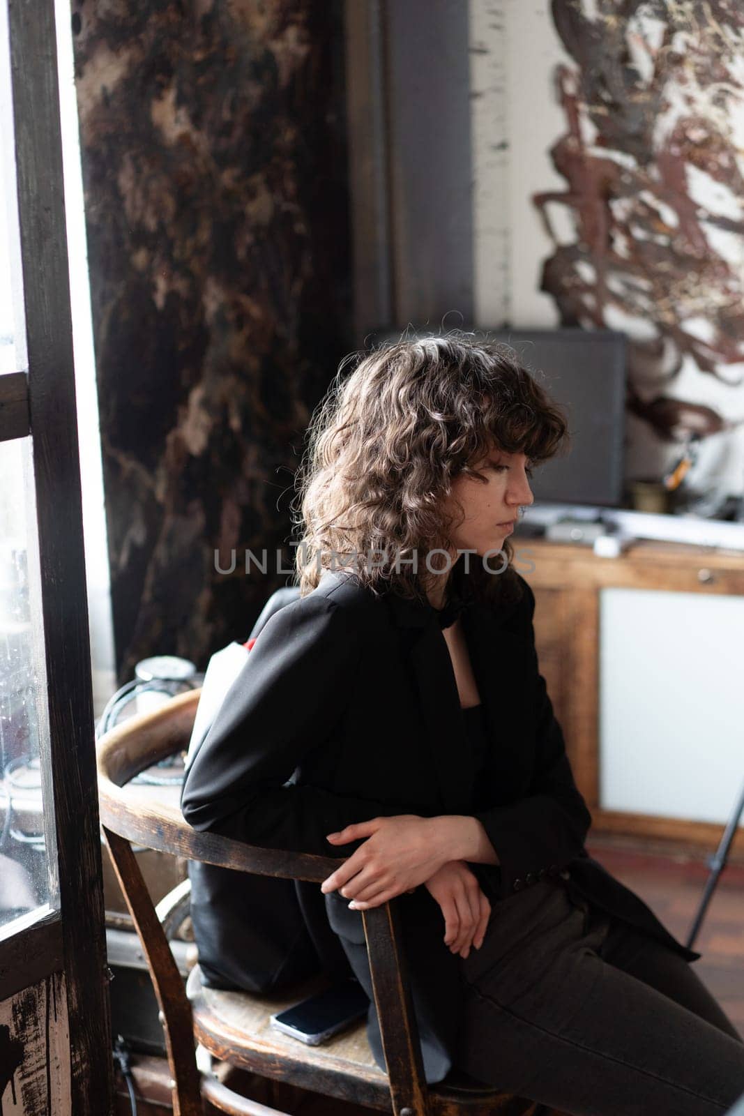 portrait of a young beautiful woman with curly hair in the studio