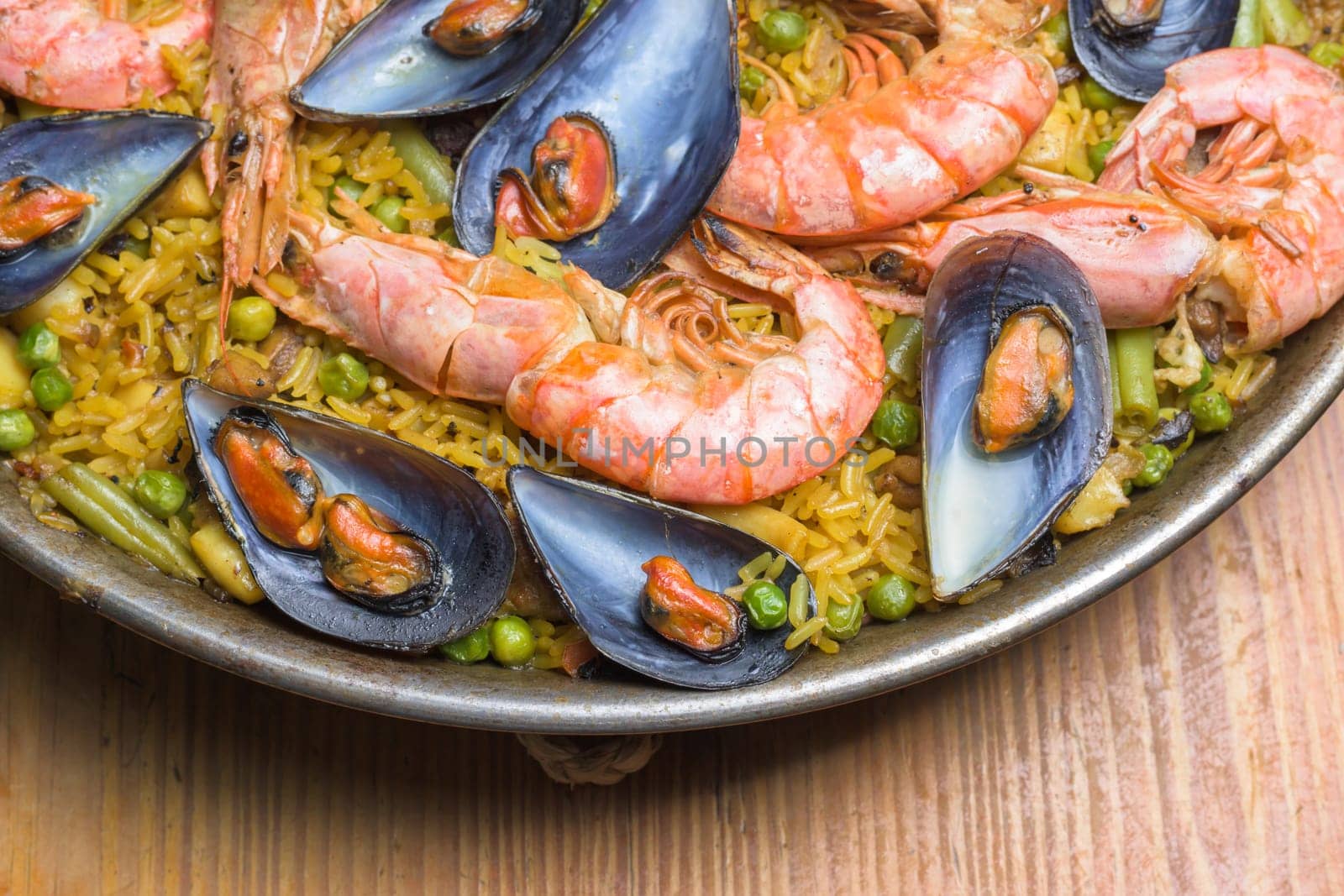 Freshly cooked seafood paella with vibrant colors served in a rustic pan, typical Spanish cuisine, Majorca, Balearic Islands, Spain by carlosviv