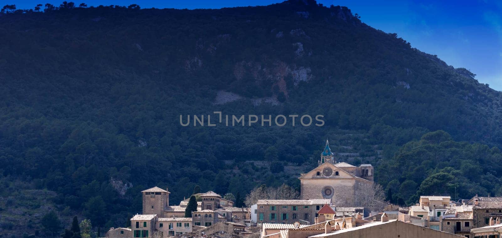 Nestled Village Church Against the Verdant Slopes of a Mountainous Landscape by Juanjo39