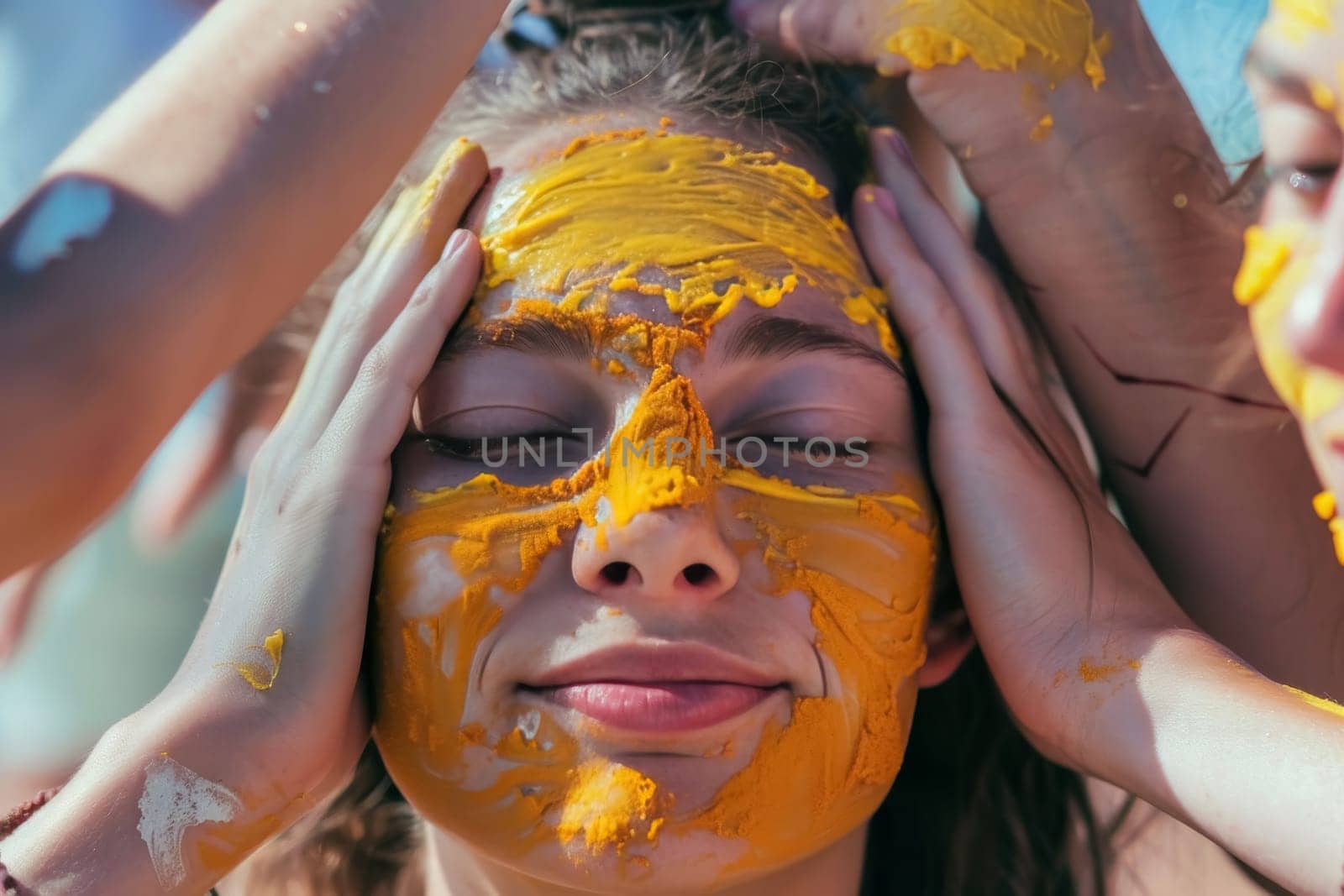Friends apply turmeric paste on a woman's face during a pre-wedding ceremony. The intimate moment is rich with tradition and the golden hue of turmeric