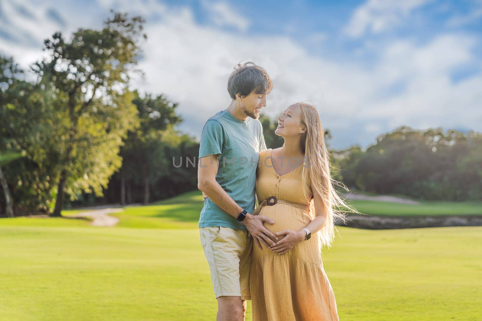 A blissful moment as a pregnant woman and her husband spend quality time together outdoors, savoring each other's company and enjoying the serenity of nature.