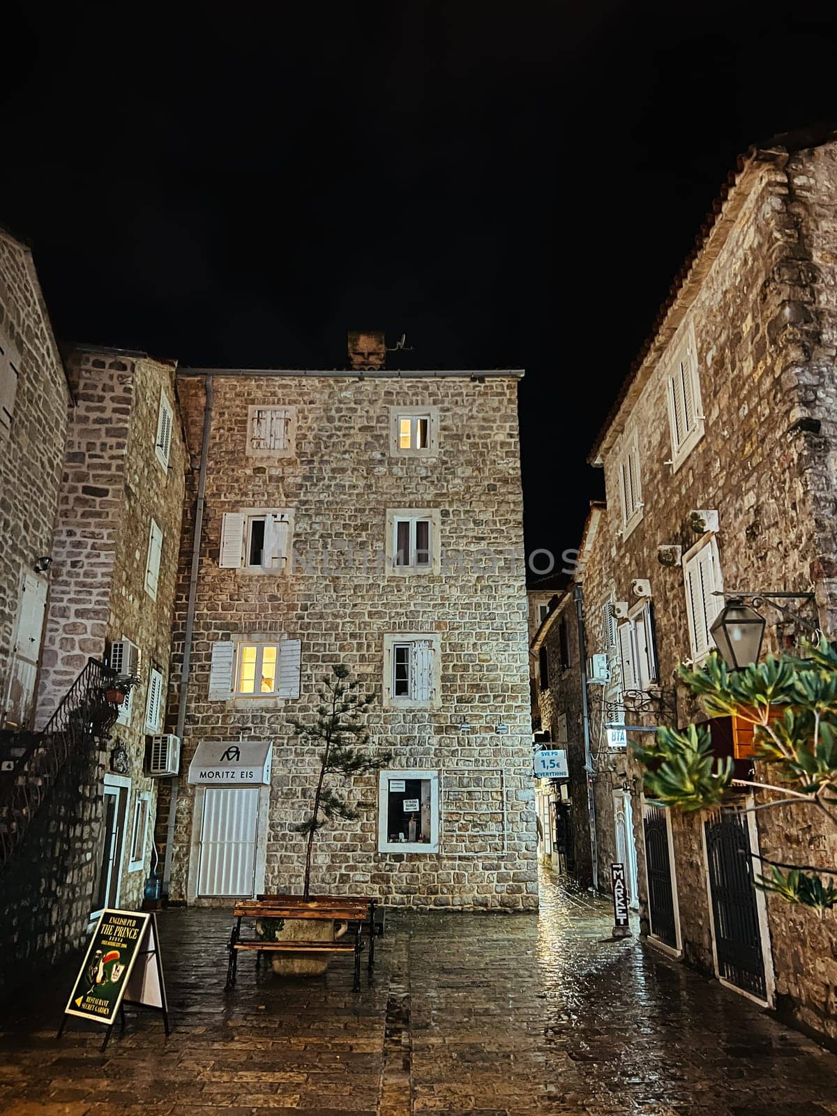 Budva, Montenegro - 25 december 2022: Cozy courtyard between old stone houses by Nadtochiy