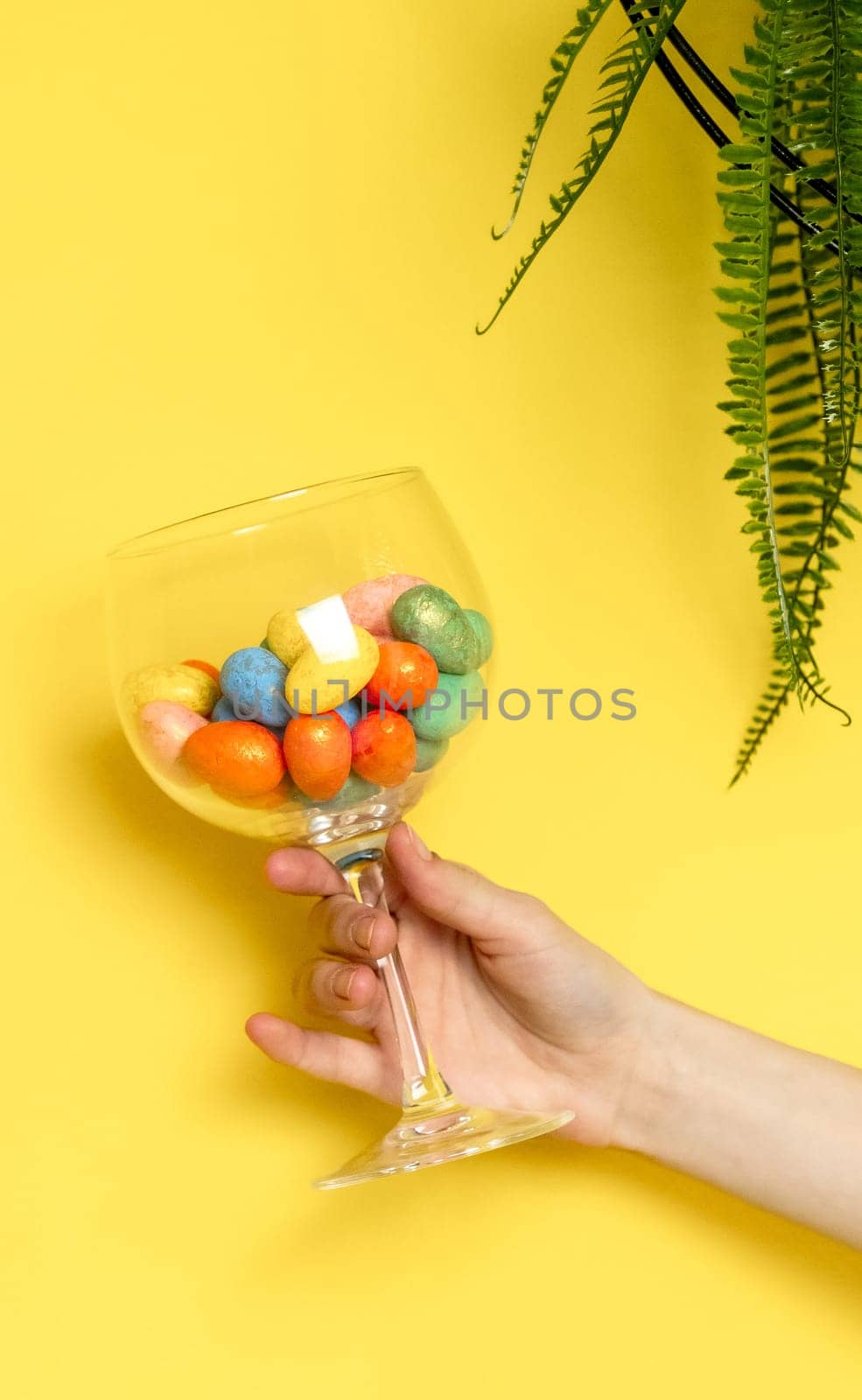 The girl hand holds a glass with Easter eggs. by Nataliya