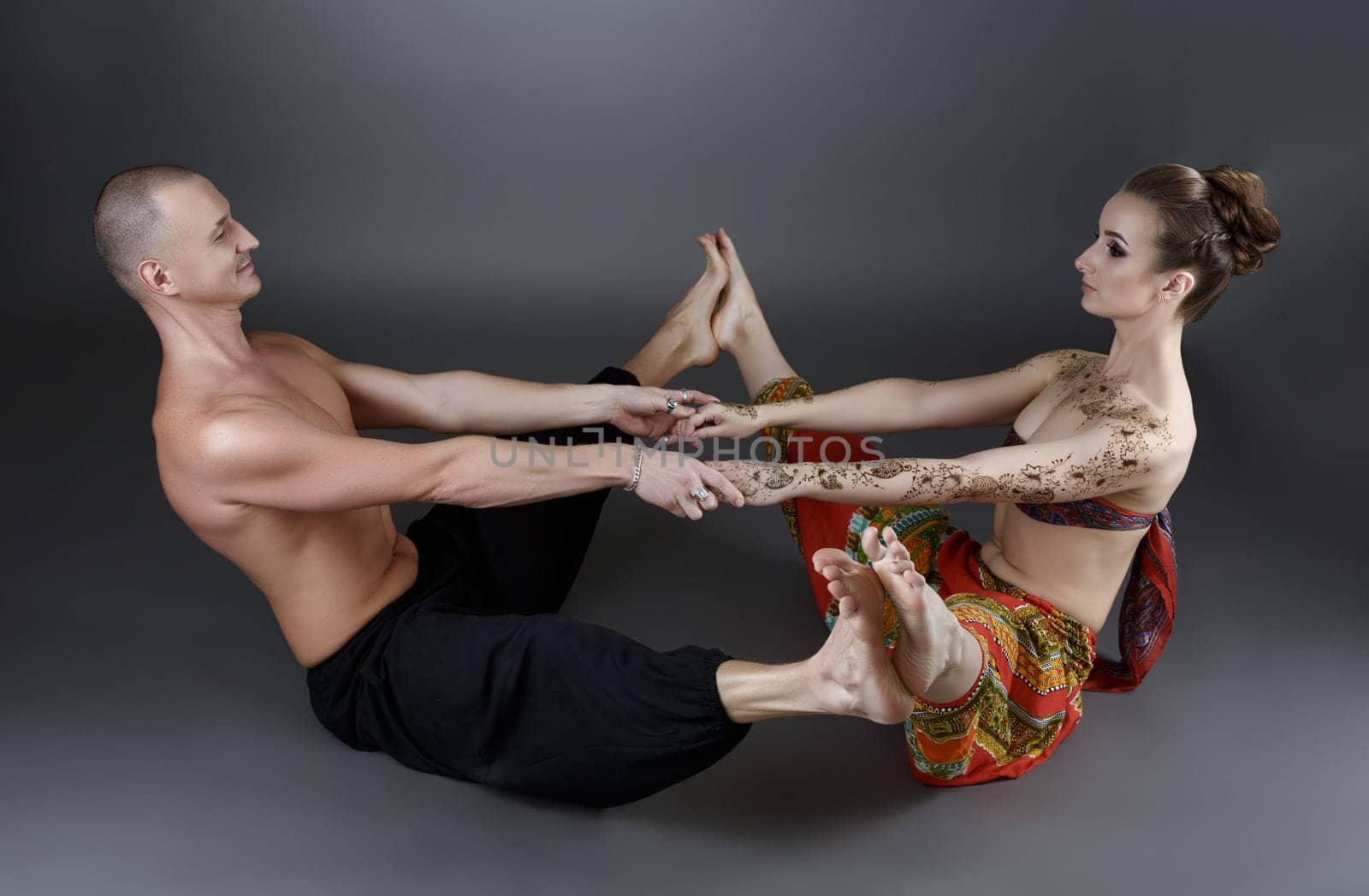 Yoga with partner. Professional trainers show one of asanas