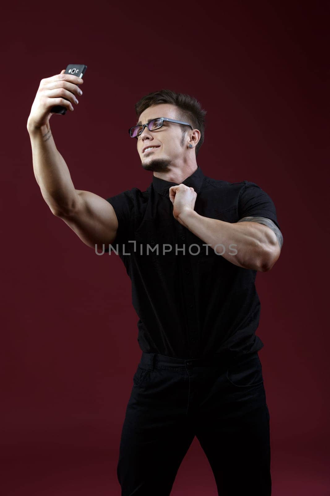 Image of stylish young guy doing selfie in studio