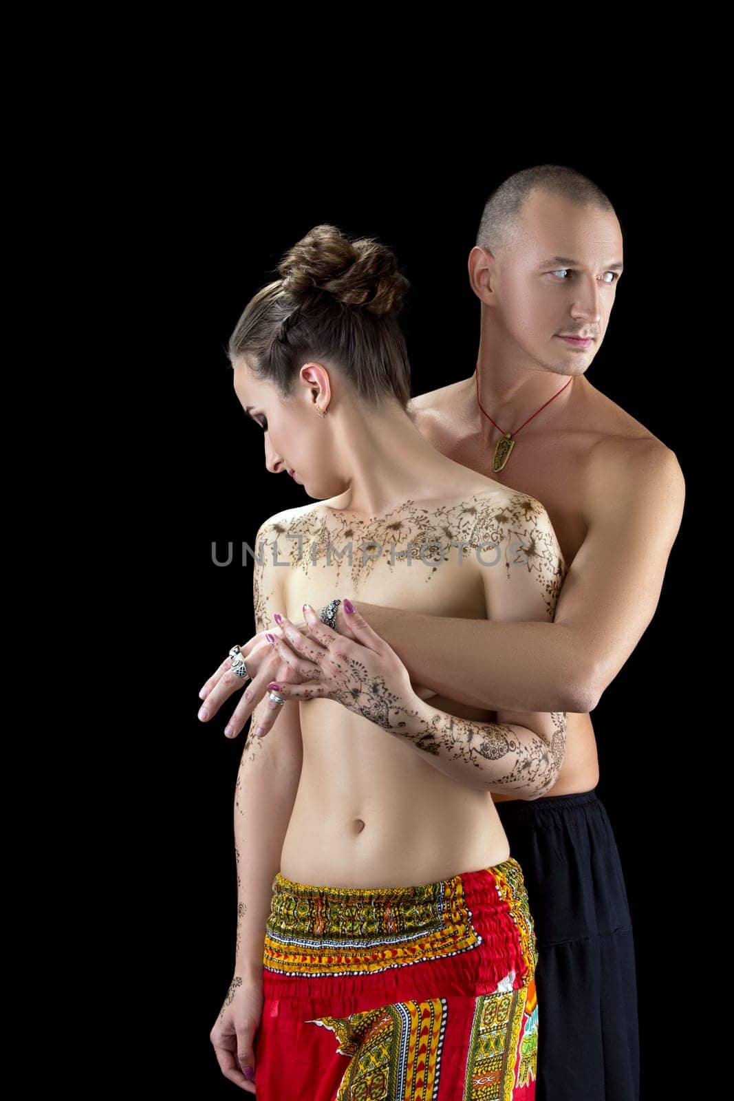 Yoga and mehndi. Photo of sensual couple posing, isolated on black
