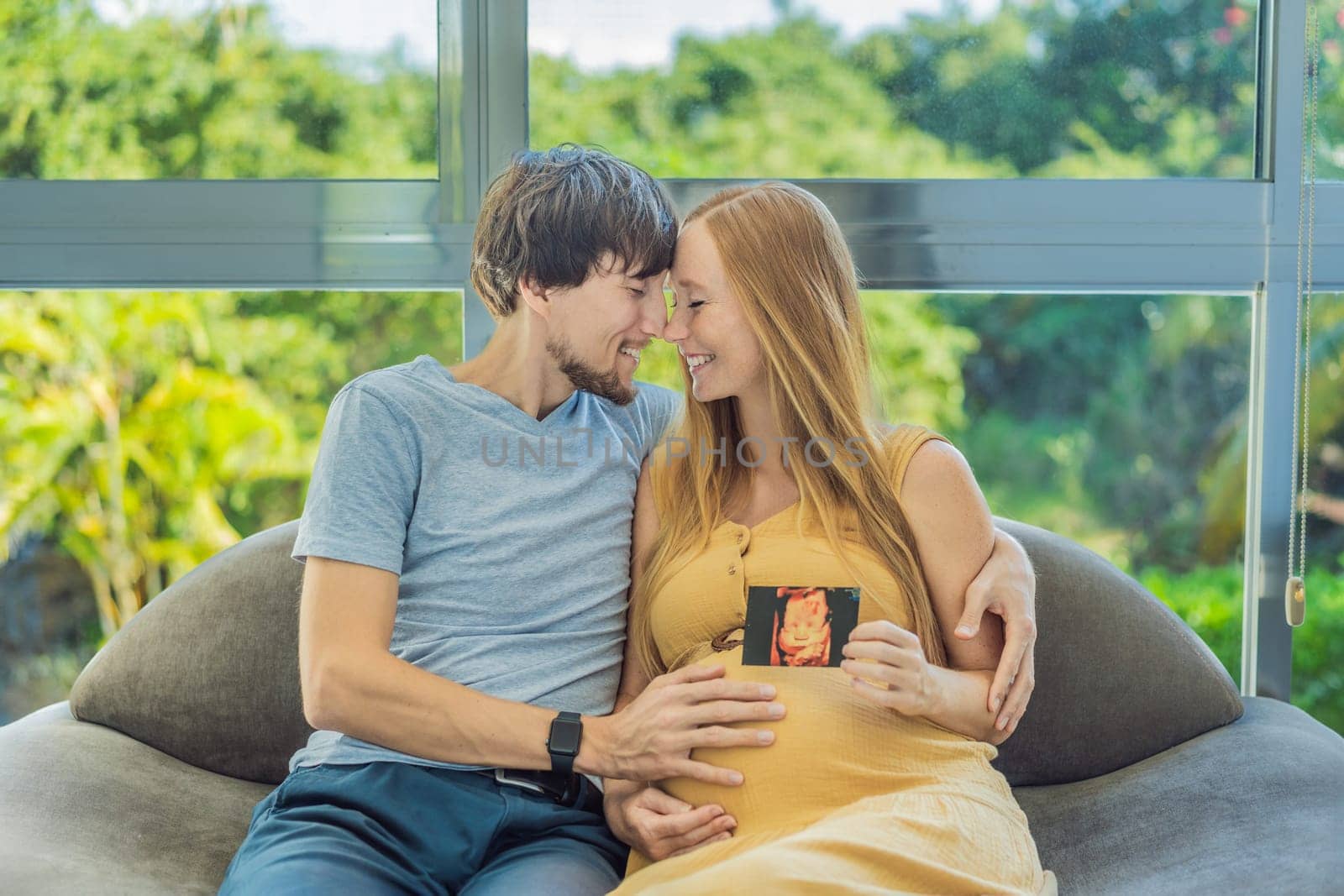 In a touching moment, the pregnant woman and father connect via video call, sharing the joy as they hold up an ultrasound photo, bridging the distance with the anticipation of their baby's arrival by galitskaya