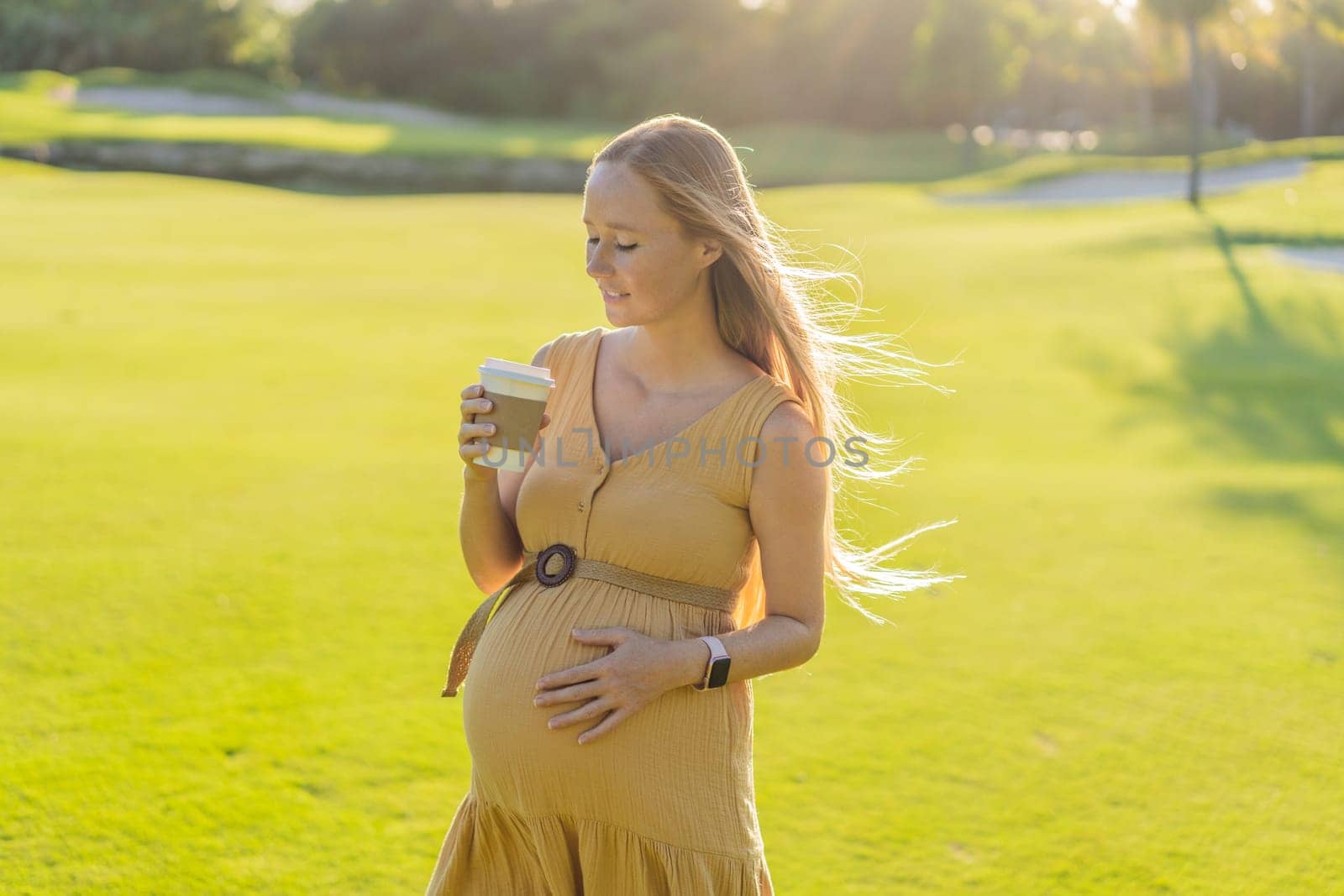 pregnant woman enjoys a cup of coffee outdoors, blending the simple pleasures of nature with the comforting warmth of a beverage during her pregnancy by galitskaya