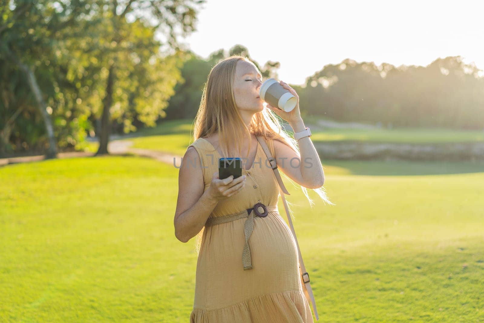 pregnant woman enjoys a cup of coffee outdoors, blending the simple pleasures of nature with the comforting warmth of a beverage during her pregnancy.