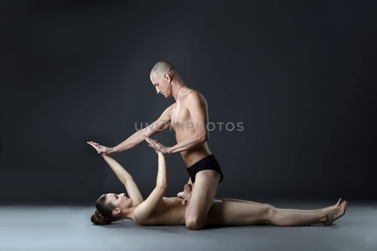 Nude paired yoga. Man in lotus position on woman by rivertime