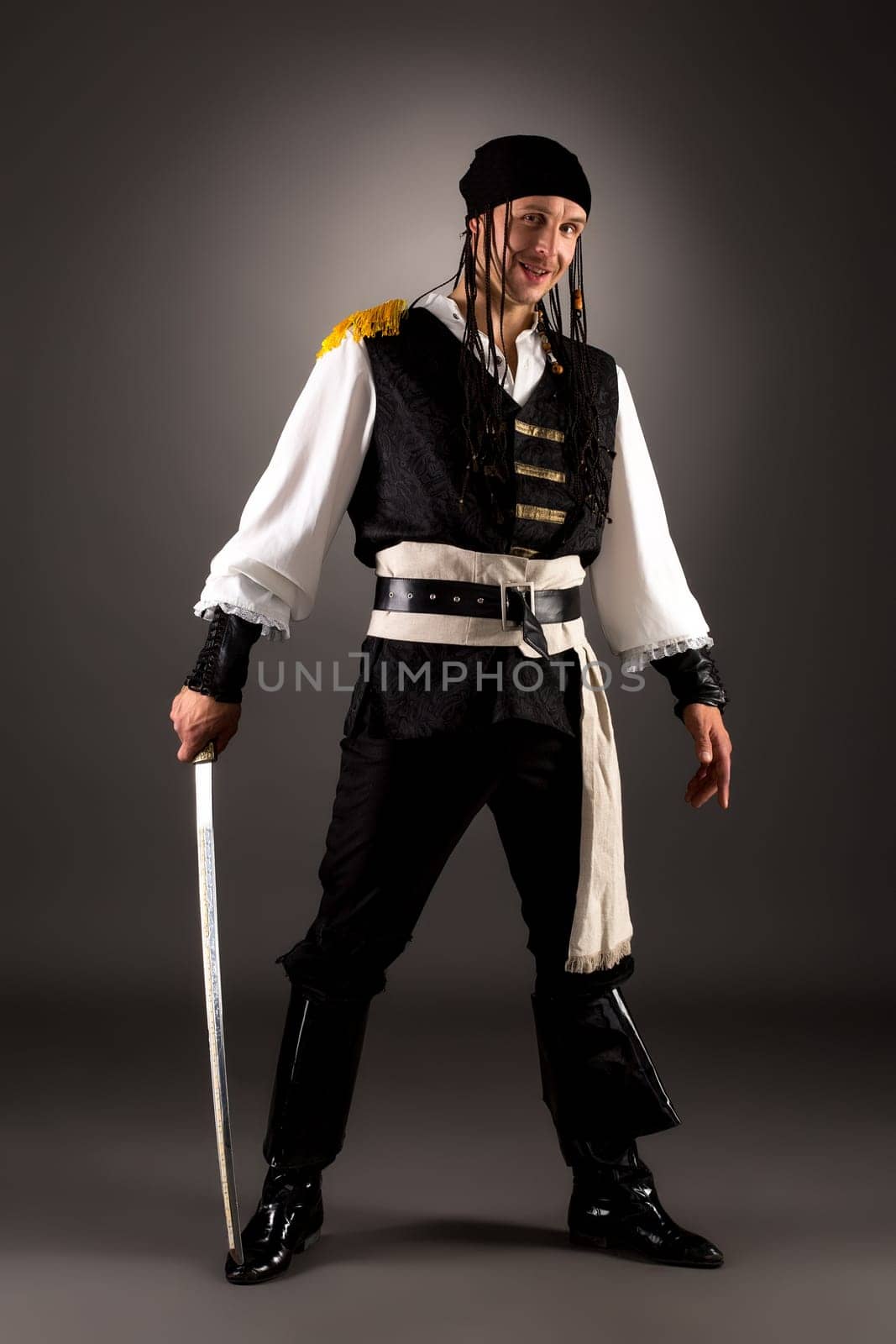 Smiling man posing as pirate at camera. Studio photo
