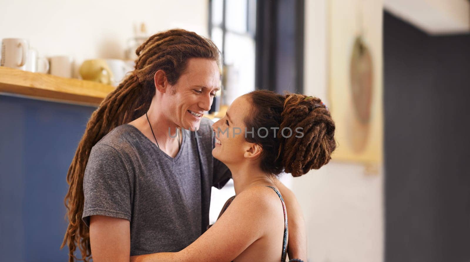 Hug, rasta and home with couple, love and bonding together with happiness and relaxing. Marriage, apartment and embrace with romance and dreadlocks with relationship and cheerful with man and woman by YuriArcurs