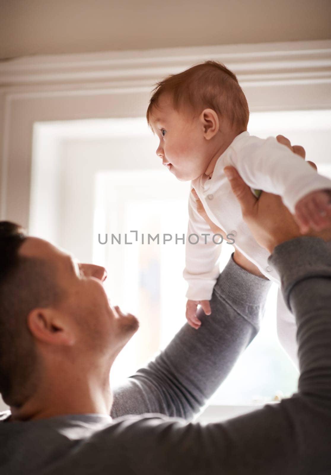 Father, baby and home with bonding, love and support together with family care and development. Dad, smile and young child in a house with parent playing with newborn and happy about infant growth.