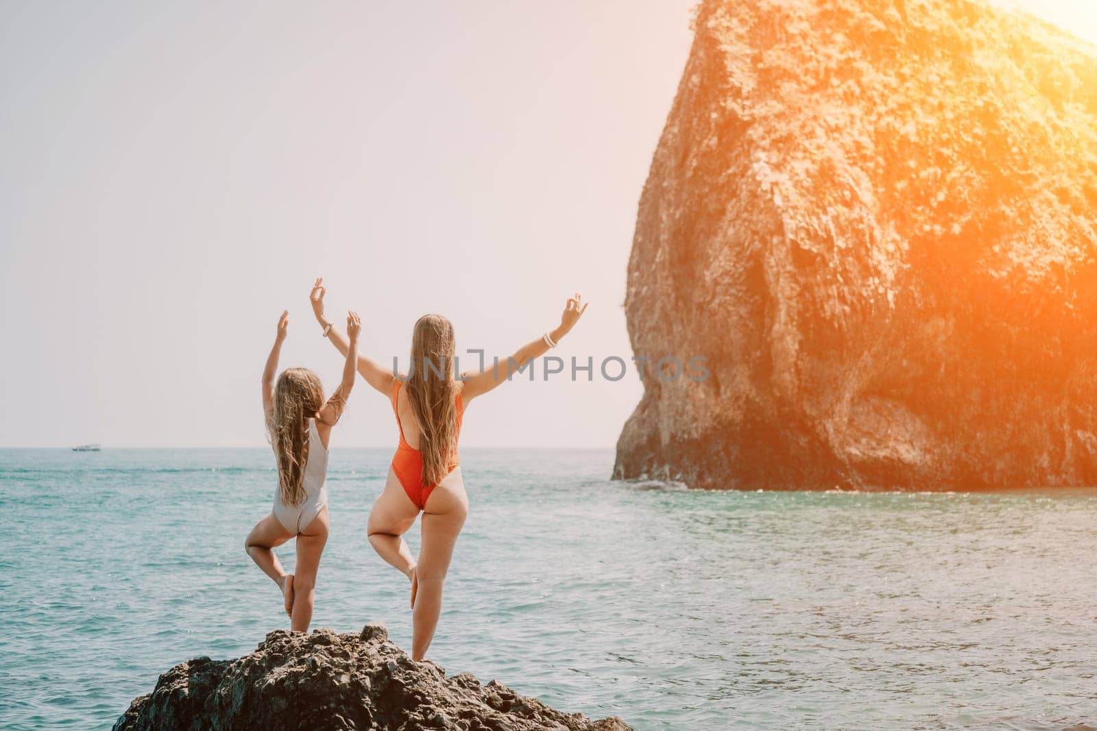 Silhouette mother and daughter doing yoga at beach. Woman on yoga mat in beach meditation, mental health training or mind wellness by ocean, sea