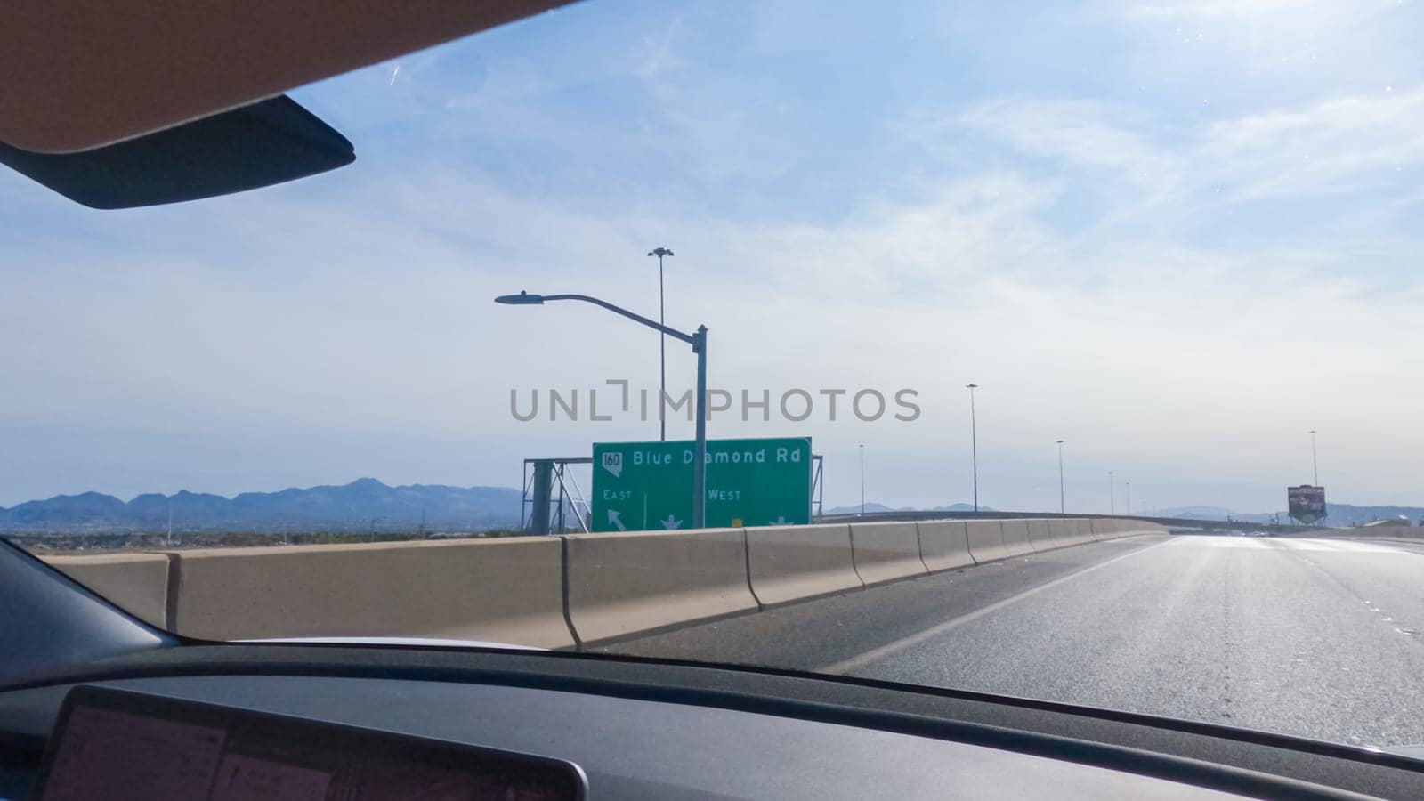 Las Vegas, Nevada, USA-December 3, 2022-Cruising through Las Vegas in a sleek Tesla vehicle on Highway 15 during the day adds an extra touch of luxury and sustainability to your road trip adventure to California.