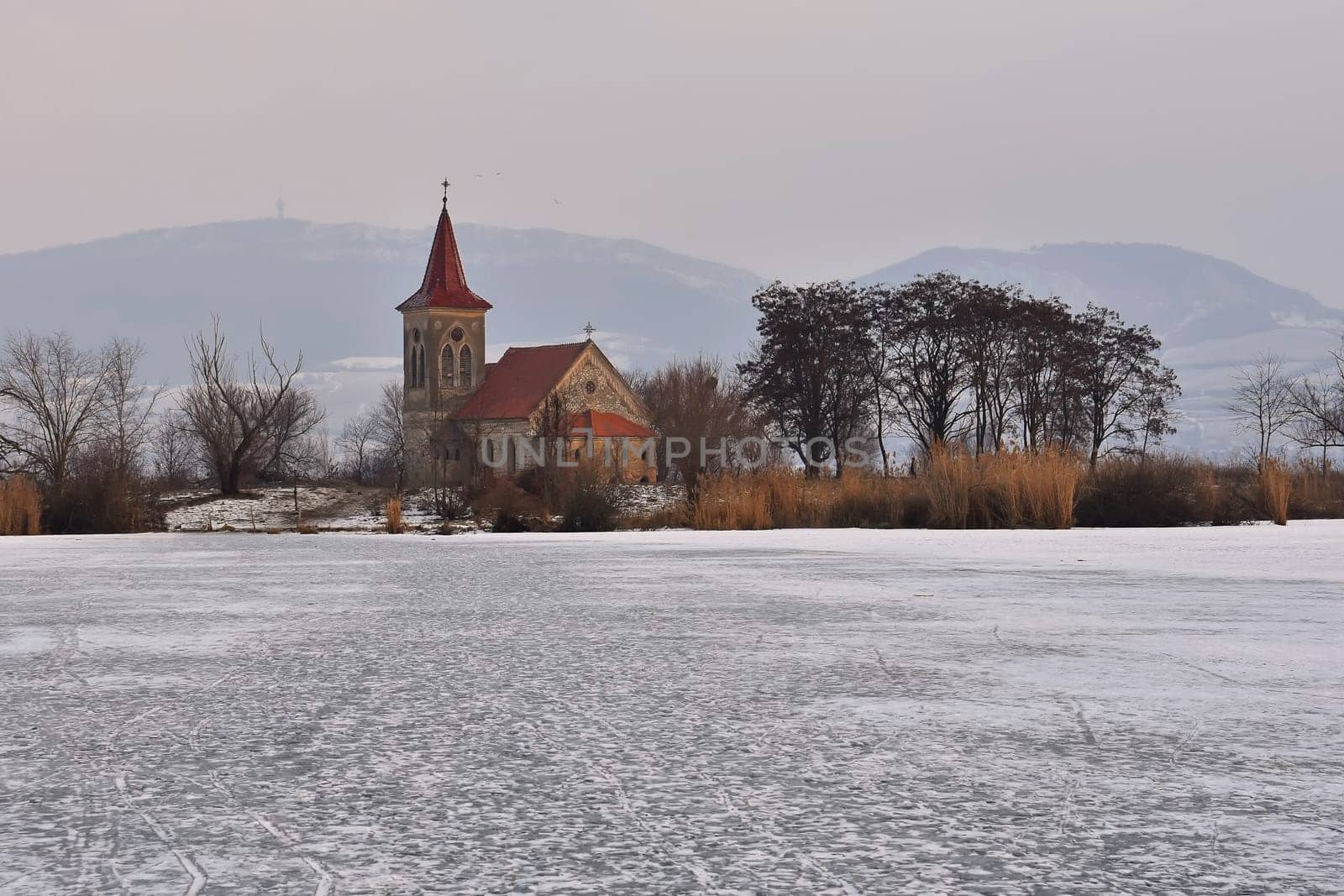 Beautiful old church of St. Linhart. Catholic temple village of Musov - Pasohlavky, Czech Republic. Photo of winter landscape with sunset on a dam New Mills (Nove Mlyny). by Montypeter