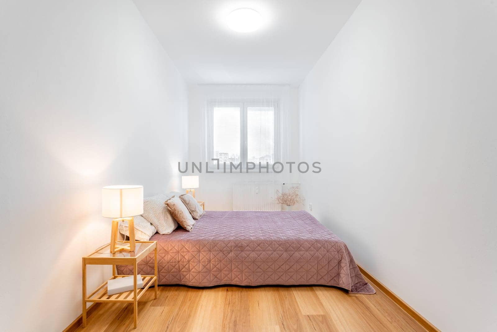 Well-lit, contemporary bedroom boasting a comfortable bed and minimalist decor