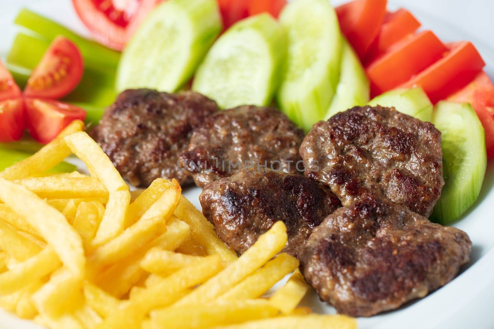 Traditional Turkish meatballs served with French fries tomatoes by senkaya