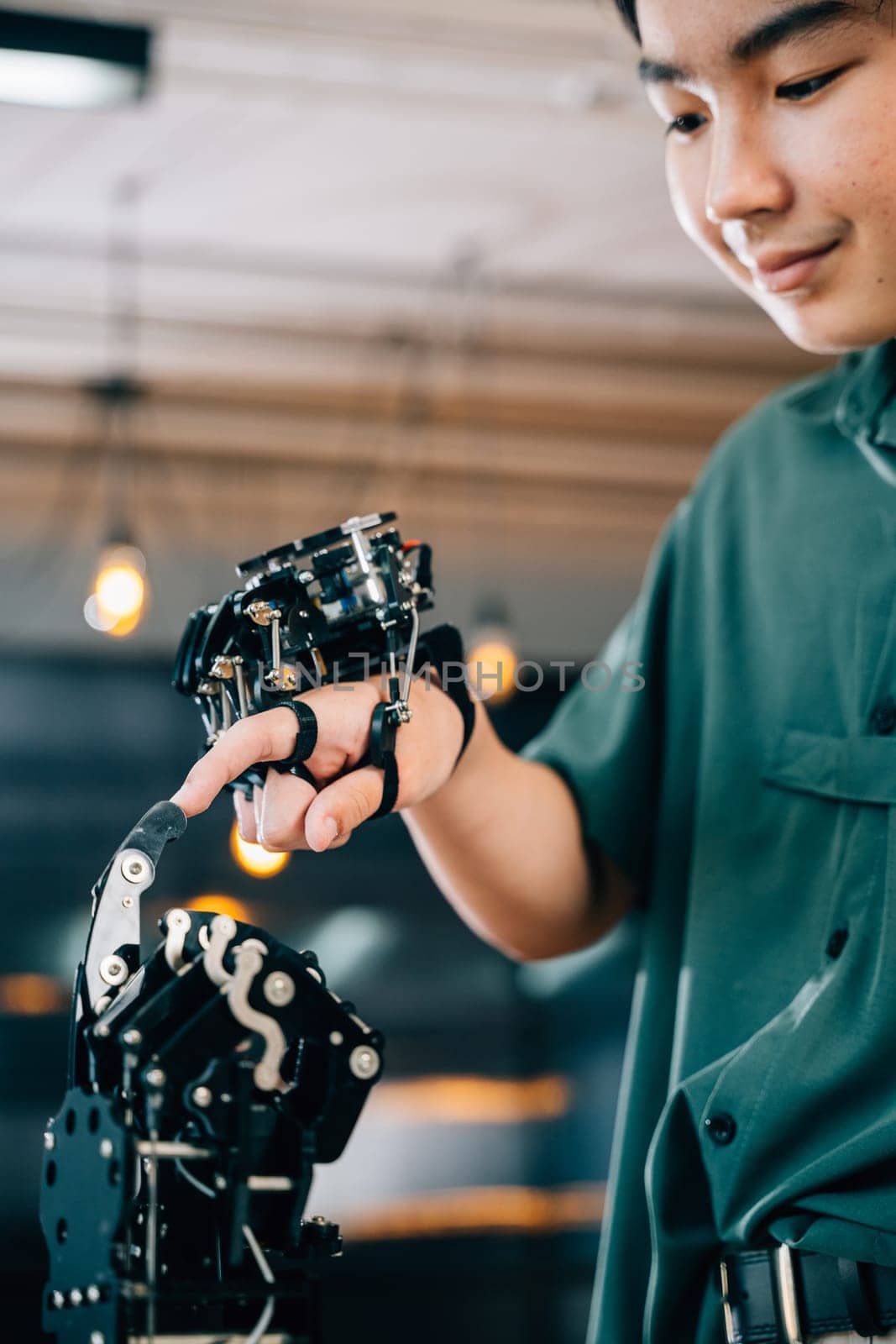 Teenage boy explores technology testing a robot hand and arm in a technical college. Embracing AI humanity and innovative learning experiences. by Sorapop