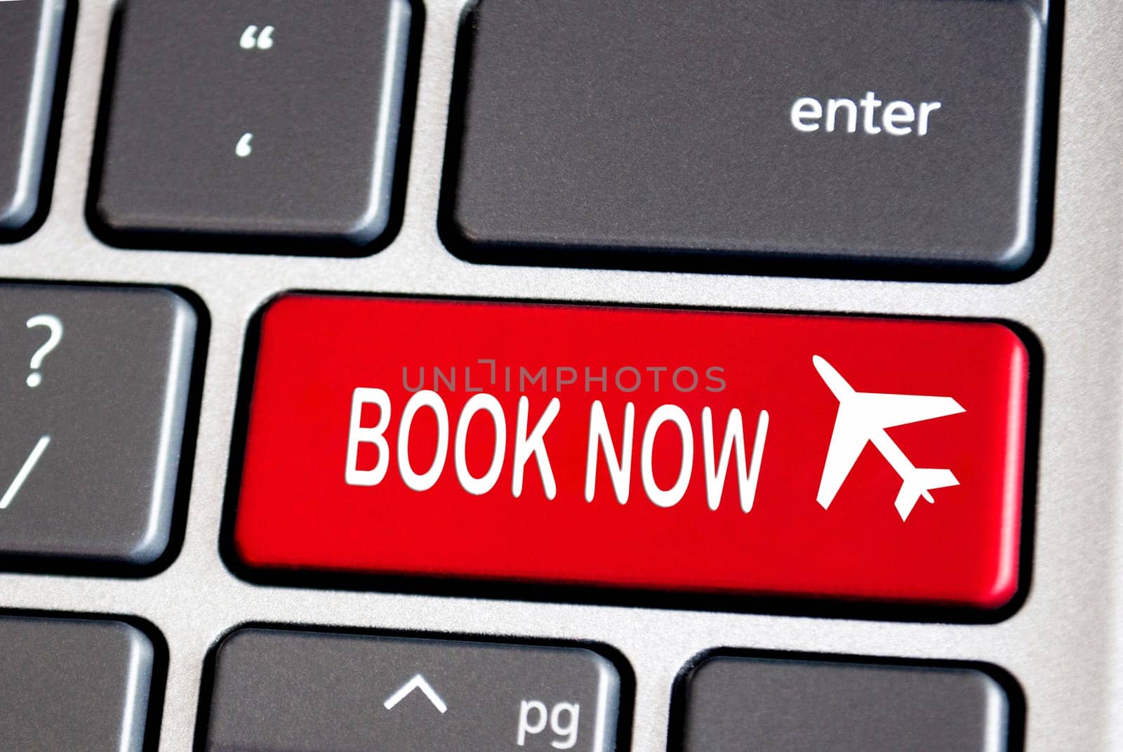 Book now text on red keyboard. Traveling concept.