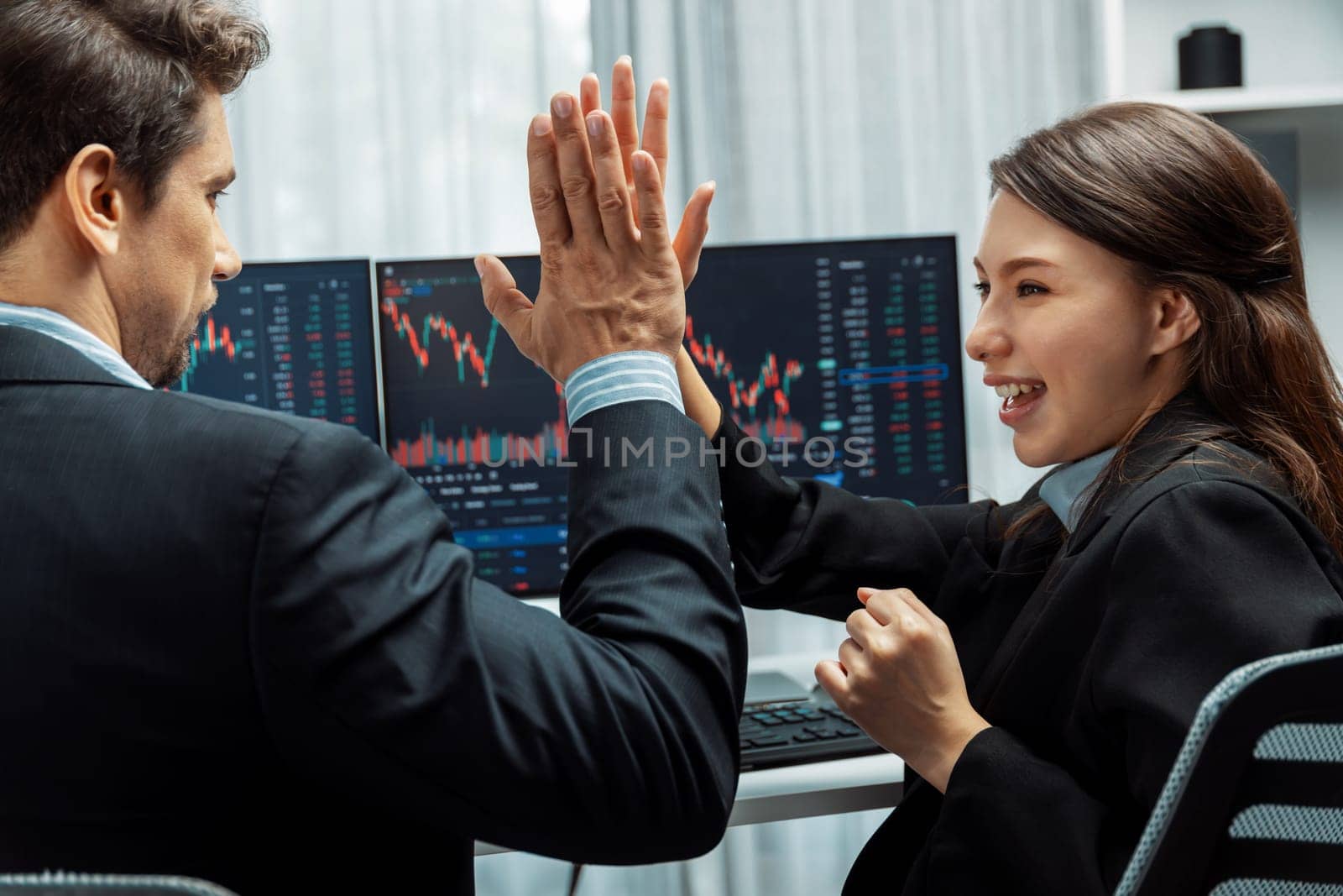 Successful in two business traders making hands high five with fist up to earn highest profit stock market in value currency online website on pc screens in real time data at modern office. Postulate.