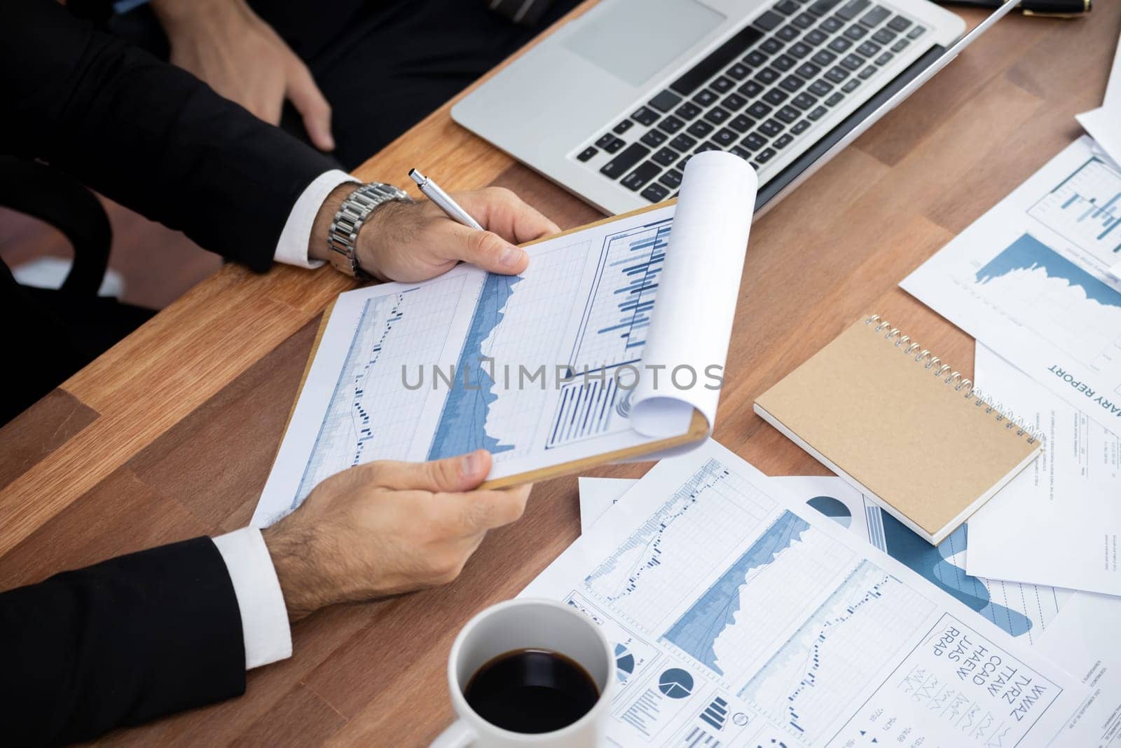 Diverse group of business analyst team analyzing financial data report paper on office table. Chart and graph dashboard by business intelligence analysis for strategic marketing planning Meticulous