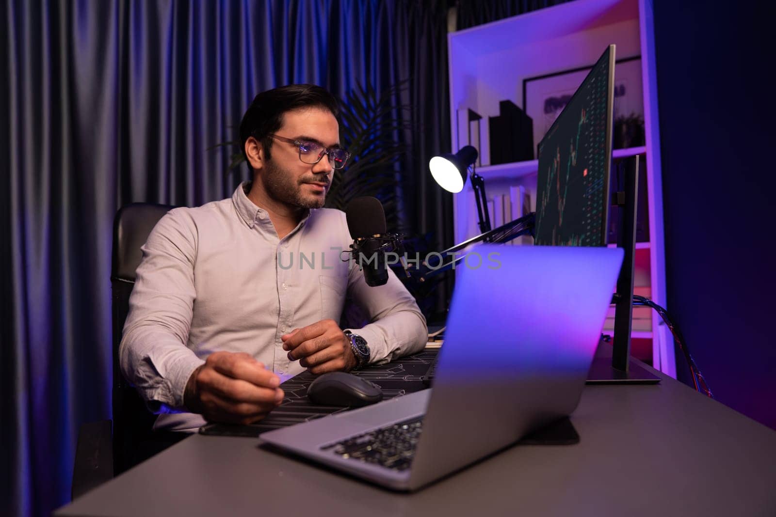 Smart trader businessman concentrating on dynamic stock exchange investment on pc and laptop showing on screen with high profit in searching market at neon light office in dark room night. Surmise.