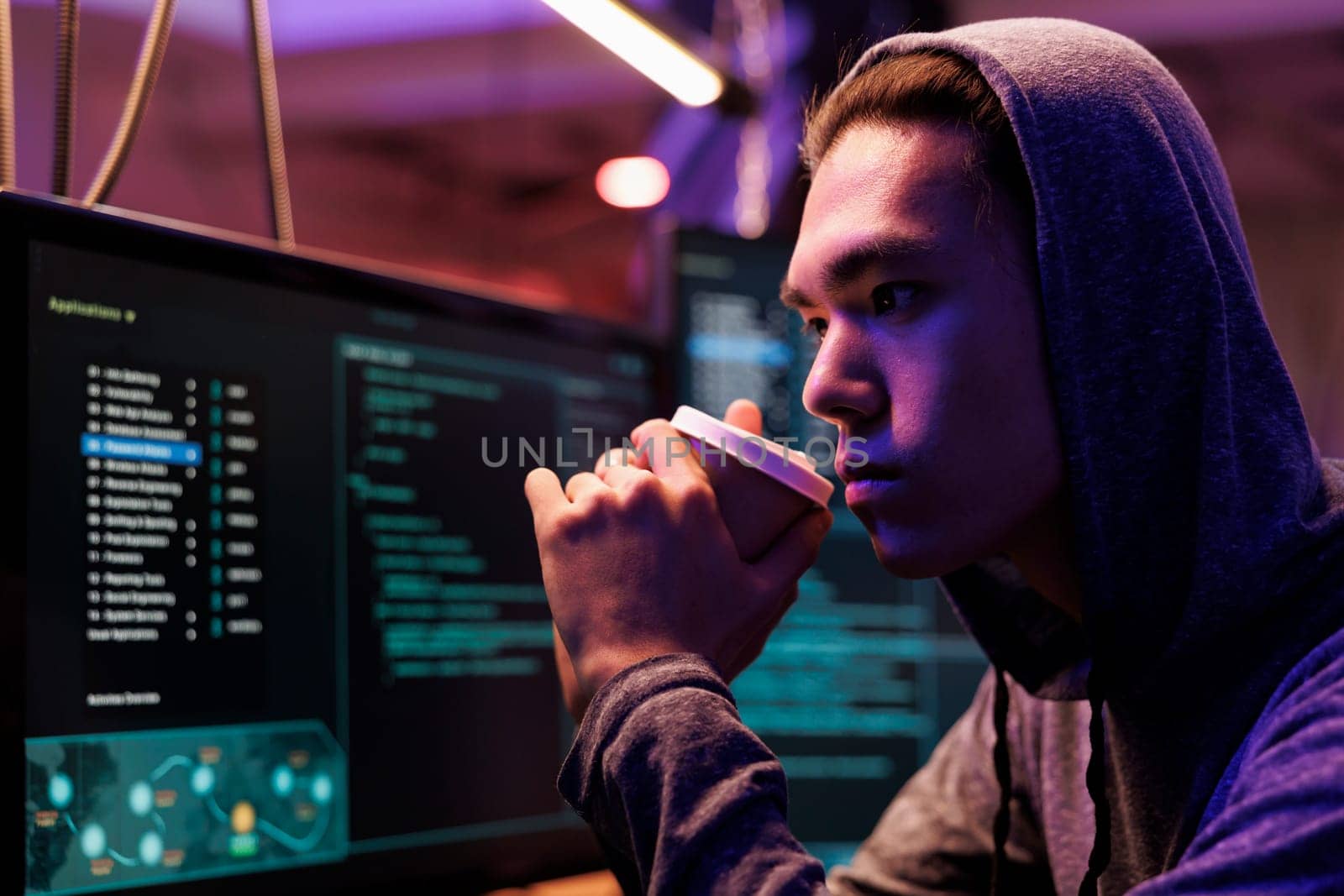 Asian hacker drinking coffee by DCStudio