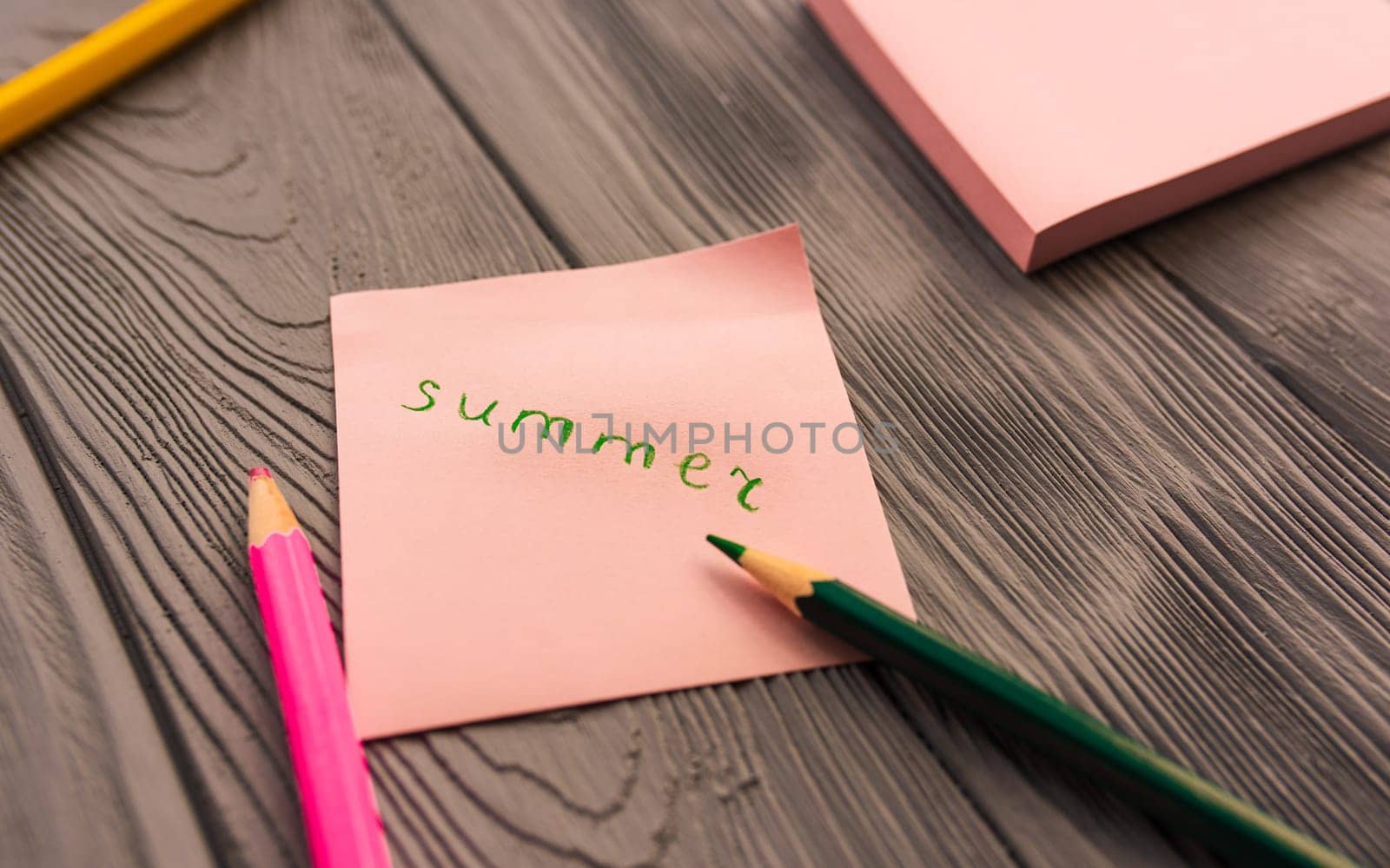 artist multicolored pencils sketch paper card inscription summer. Yellow red blue pencils. Summer background template mockup space blank colorful composition text. Top view above wooden background