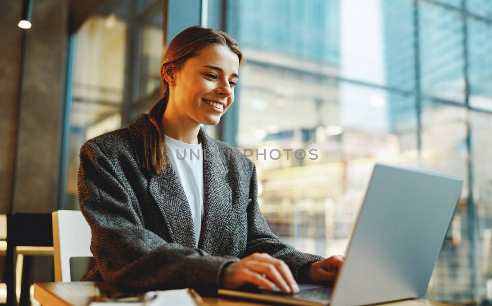 Smiling woman manager working on laptop while sitting in cozy cafe. High quality photo by Yaroslav_astakhov