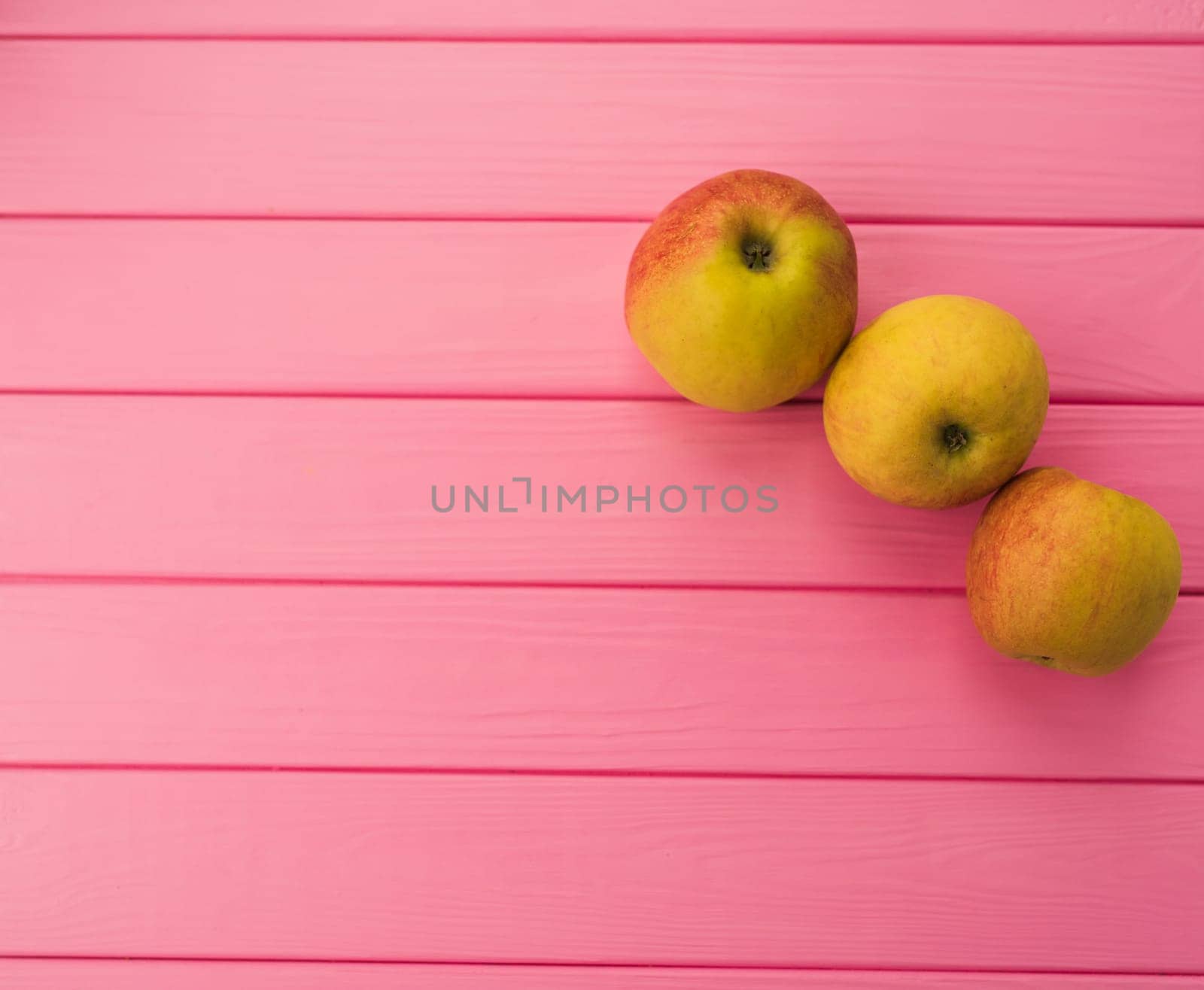 Summer abstract background mockup template free copy space for text pattern sample top view above on pink wooden board. blank empty area for inscription. fresh red apples organic fruits vegetarian