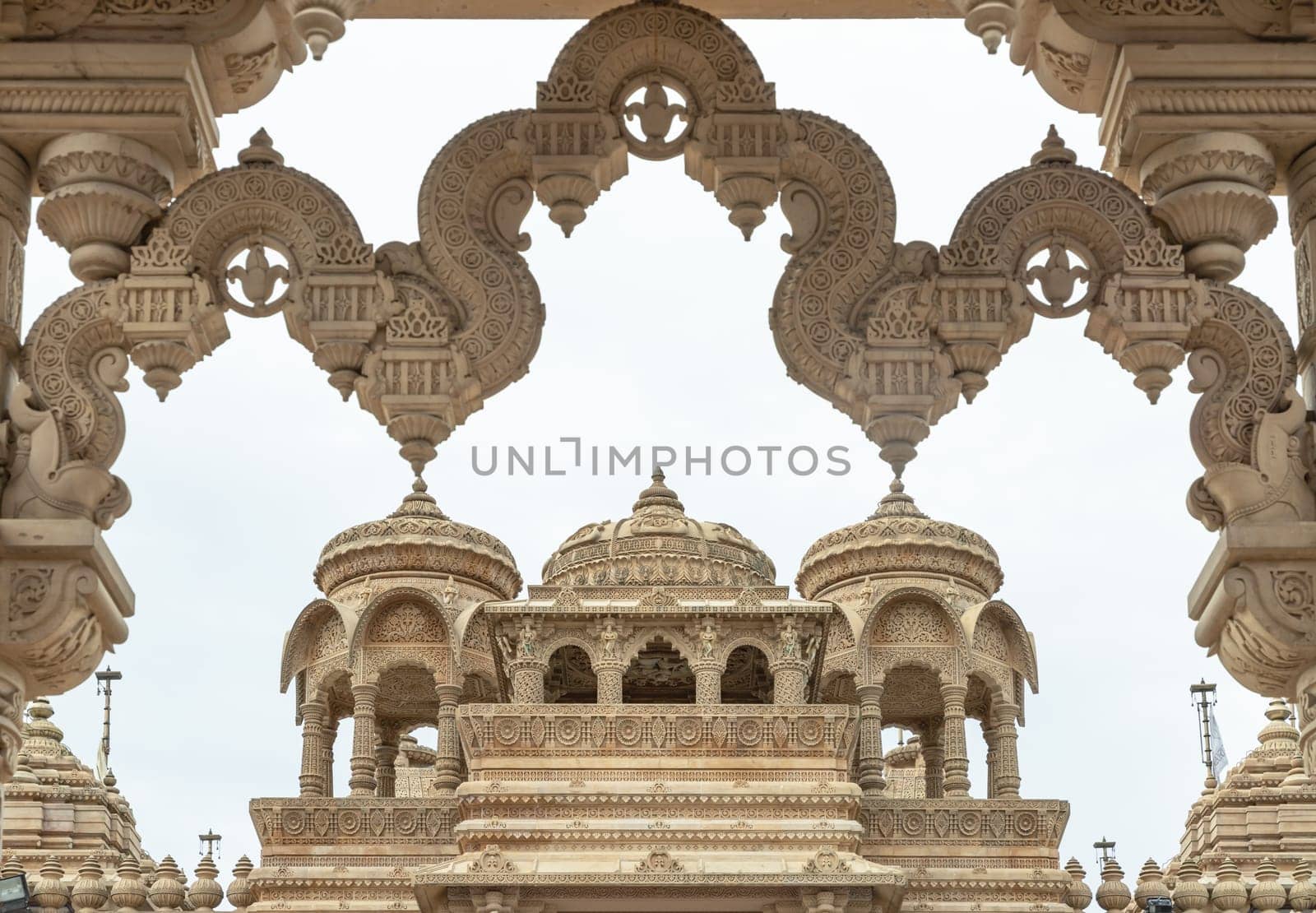 London, UK - Feb 27, 2024 - Entrance archway of The Shree Sanatan Hindu Mandir Hindu Temple (The Shri Sanatan Hindu Temple). Gates of Neasden Temple build from Elaborately carved Jaisalmer limestone, Space for text, Selective focus.