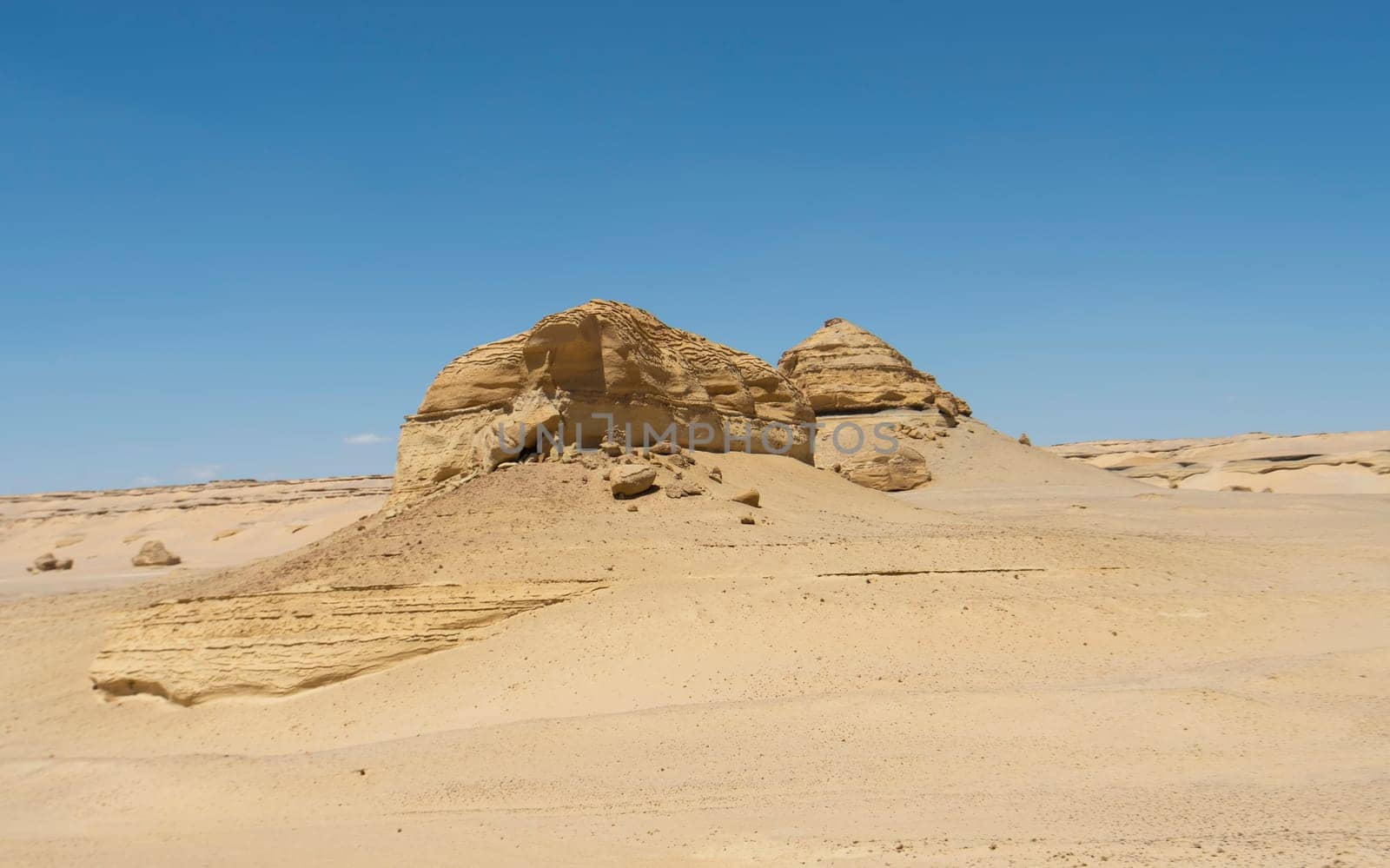 Barren desert landscape in hot climate with mountain rock formation by paulvinten