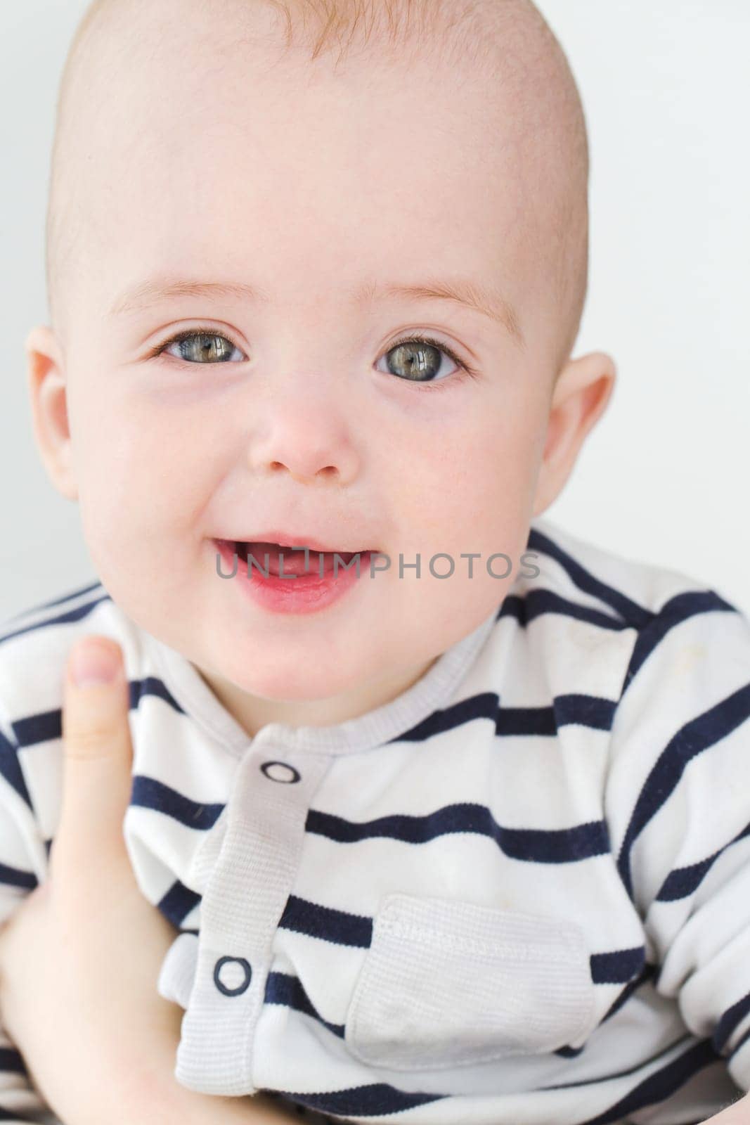 Vertical studio portrait of adorable little boy looking at camera.