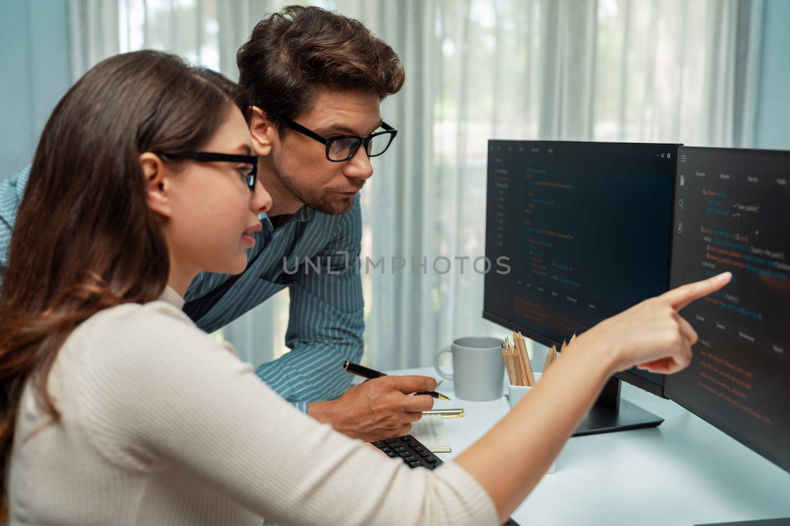 Team skilled developers program thinking newest coding creative website planning software project on two pc screen, comparing with typing full stack data analyzing prompt design at office. Postulate.