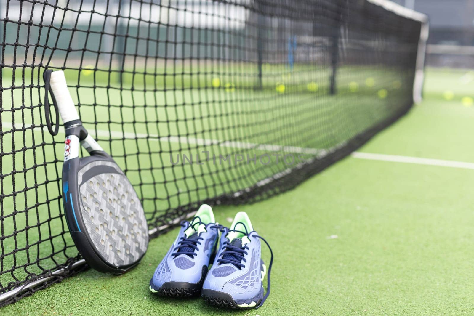 professional paddle tennis racket with natural lighting on blue background. Horizontal sport theme poster, greeting cards, headers, website and app. High quality photo