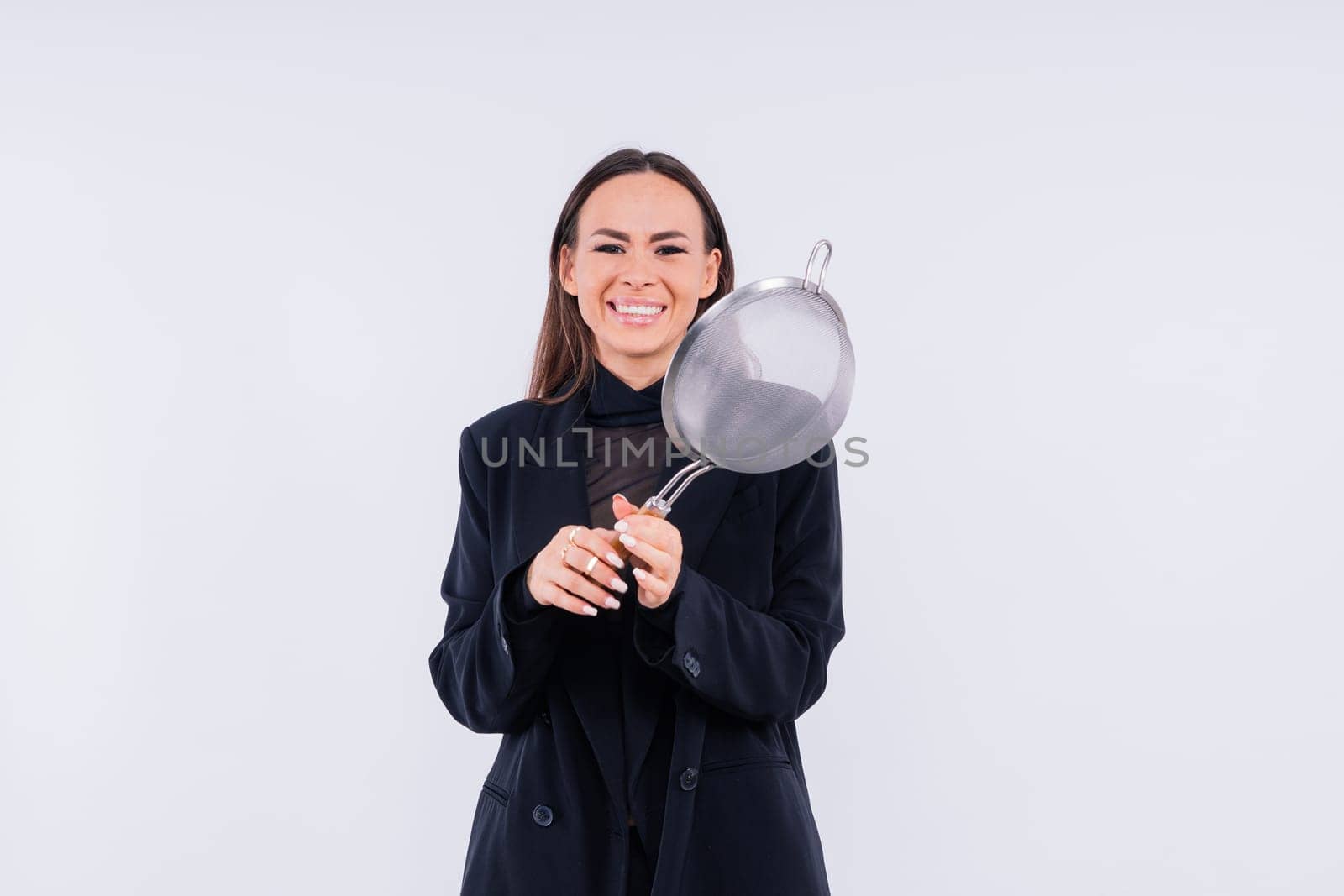 Female with metal sieve for sifting flour in a female hand on red and white background. by Zelenin