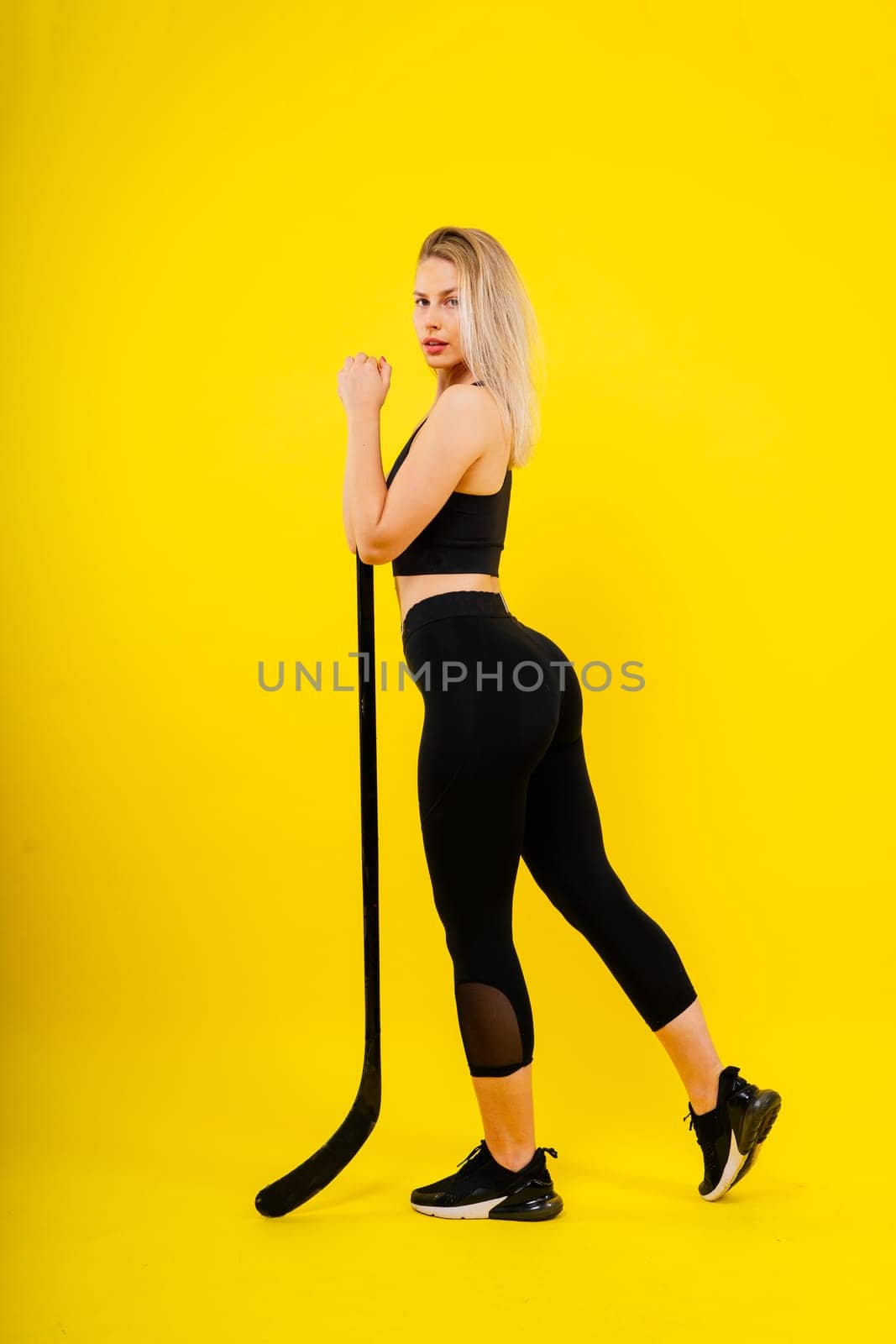 Luxuriously dressed female with hockey stick. Women's winter sports.