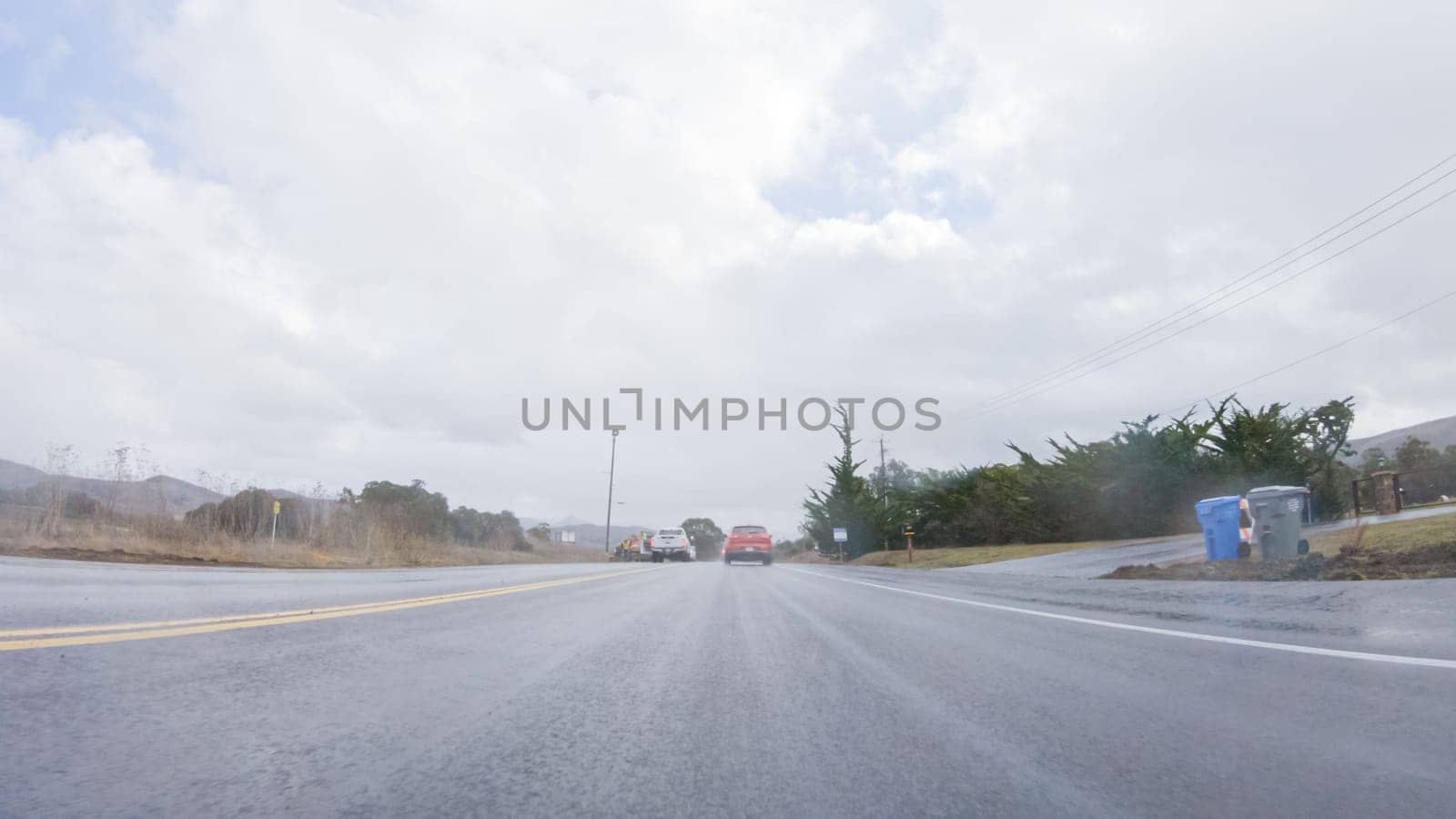 Santa Maria, California, USA-December 6, 2022-Vehicle navigates the streets of Morro Bay, California, during a cloudy winter day. The atmosphere is moody and serene as the overcast sky casts a soft light on the charming buildings and quiet streets of this coastal town.