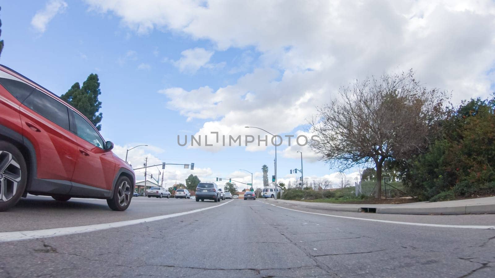 Santa Maria, California, USA-December 6, 2022-On a clear winter day, a car smoothly travels along Highway 101 near Santa Maria, California, under a brilliant blue sky, surrounded by a blend of greenery and golden hues.