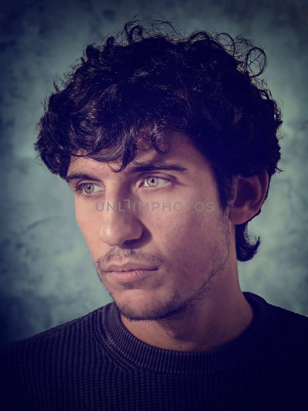 A close up, head shot of a handsome young man with green eyeswearing a black shirt