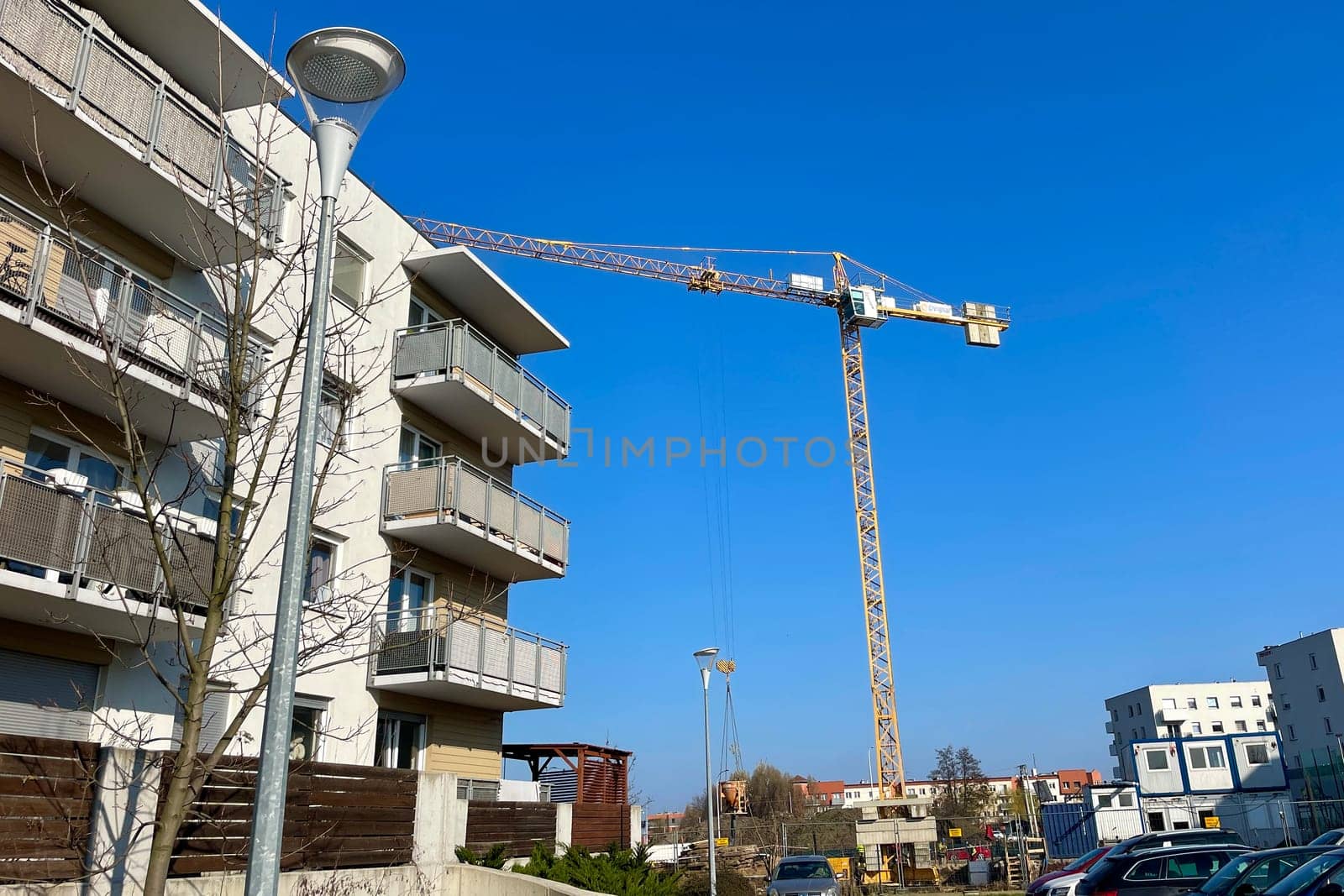 A construction tower crane is working on a construction site in the city. High quality photo