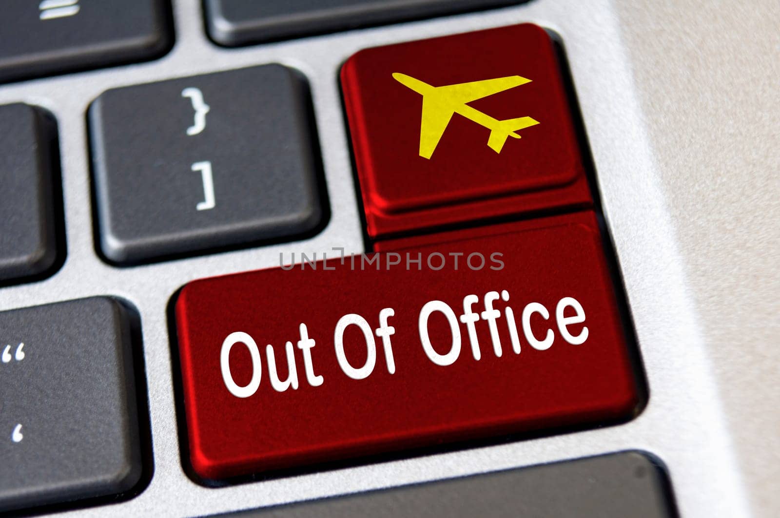Out of office text on red laptop keyboards. Vacation and holiday concept.