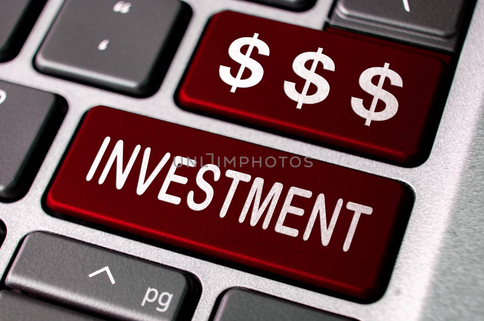 Investment text and dollar symbol on red laptop keyboards. Business investment concept.