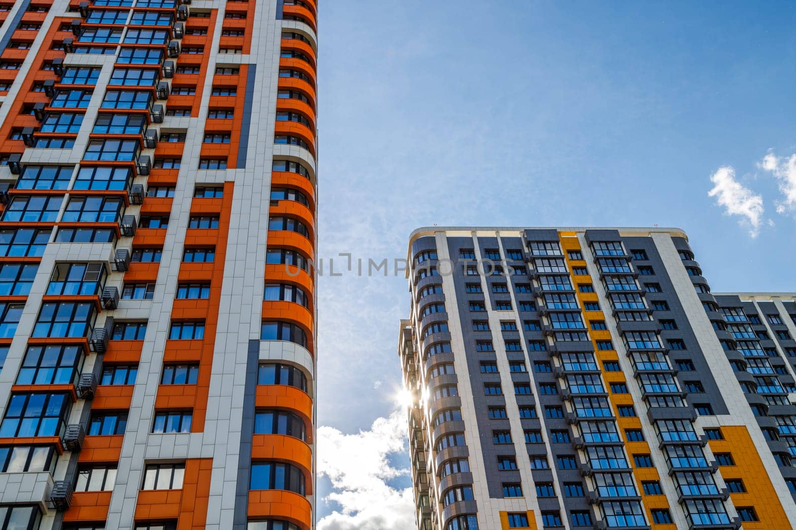 freshly built high rise apartment buildings on blue sky background with white clouds by z1b