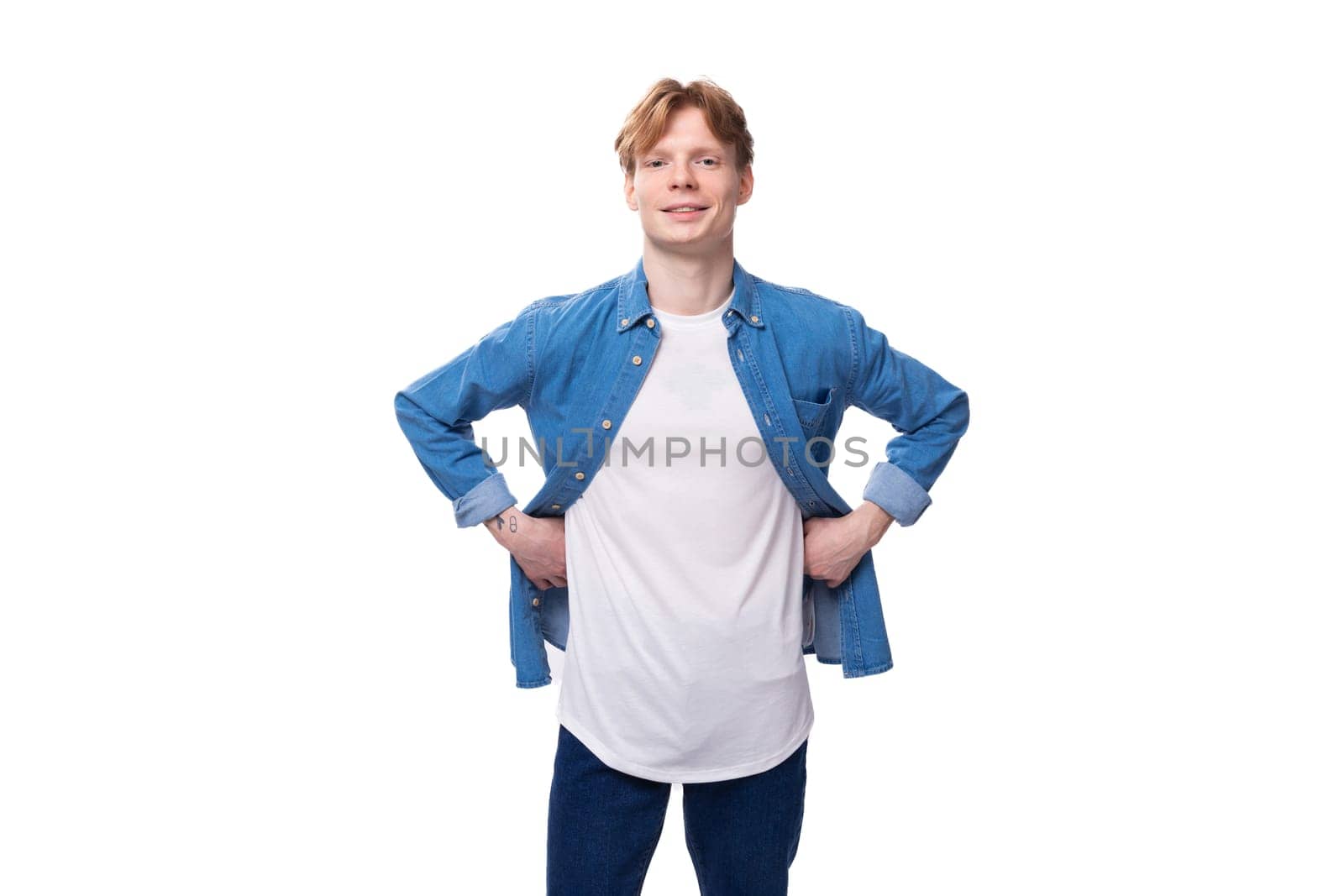 portrait of a confident caucasian red-haired guy in a denim blue shirt and a white t-shirt with a mockup for advertising.