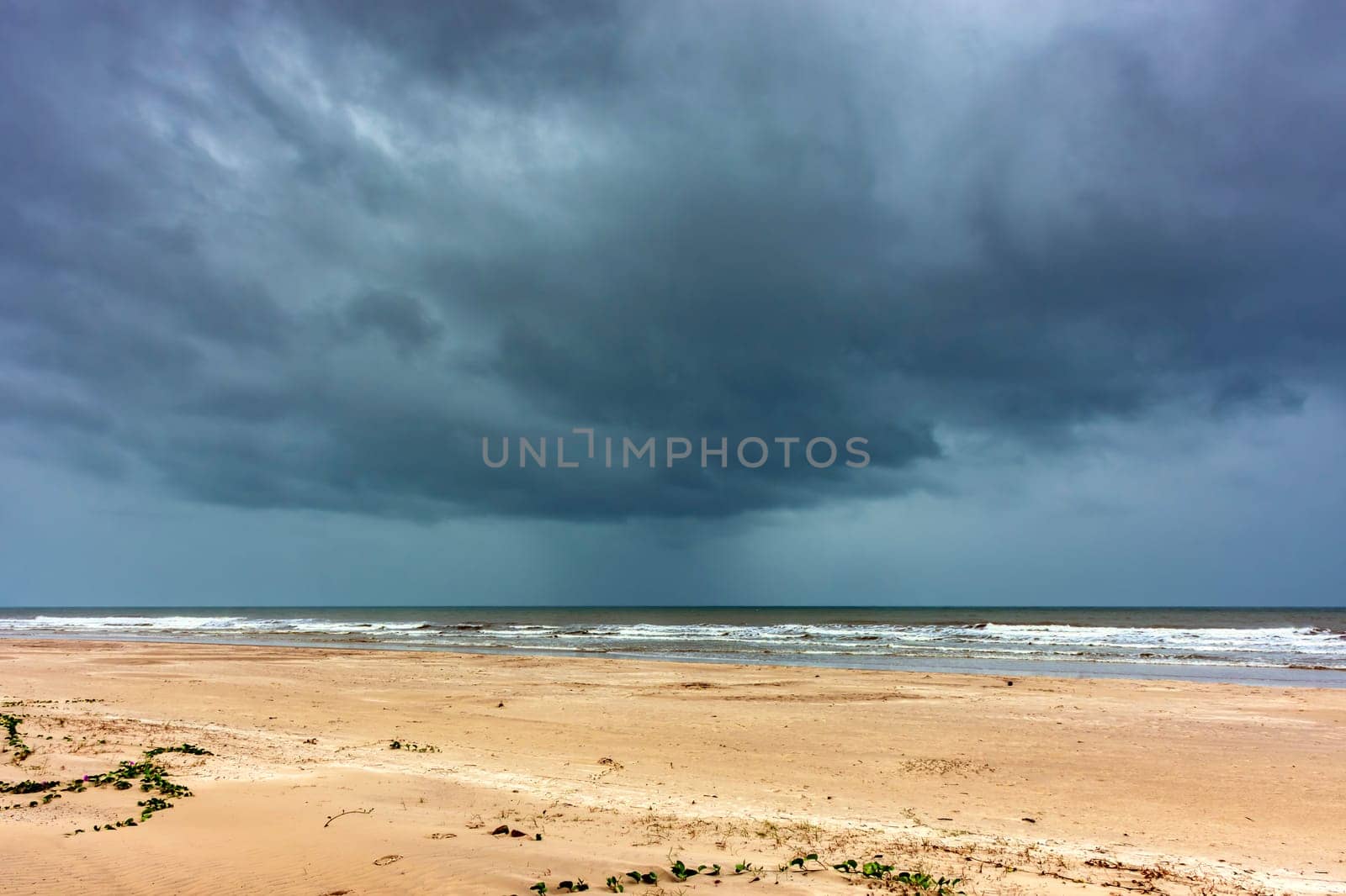 Dark rain clouds over the sea at Sargi beach in Serra Grande on the coast of Bahia